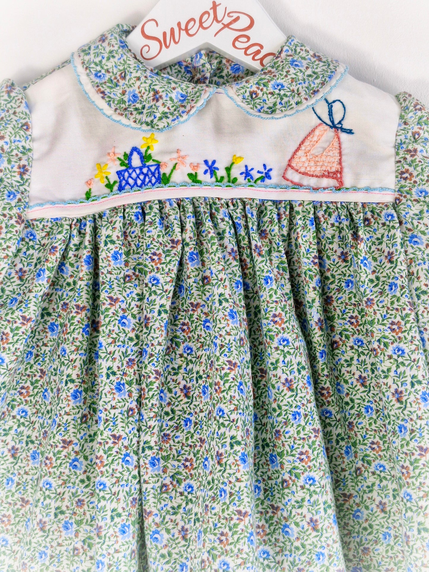 9-12 months. Collared, floral dress with embroidered details