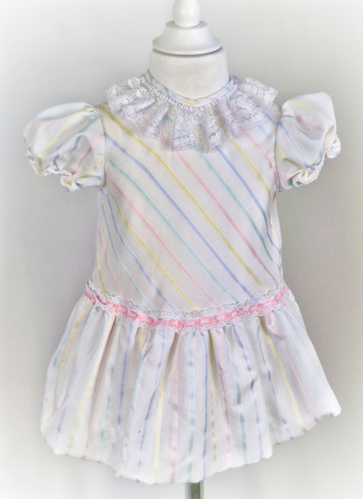 2-3 years. White dress with pastel stripes and lace collar