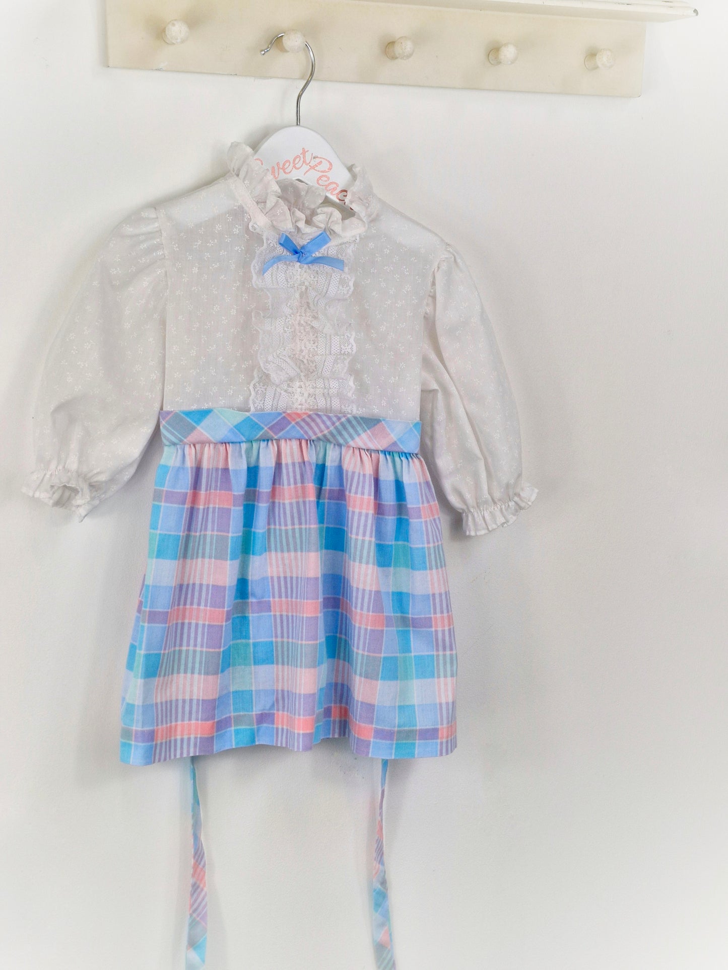 2-3 years. White New York Kids dress with pastel checked skirt and blue bow