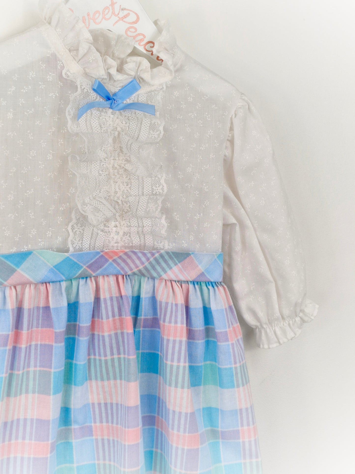 2-3 years. White New York Kids dress with pastel checked skirt and blue bow