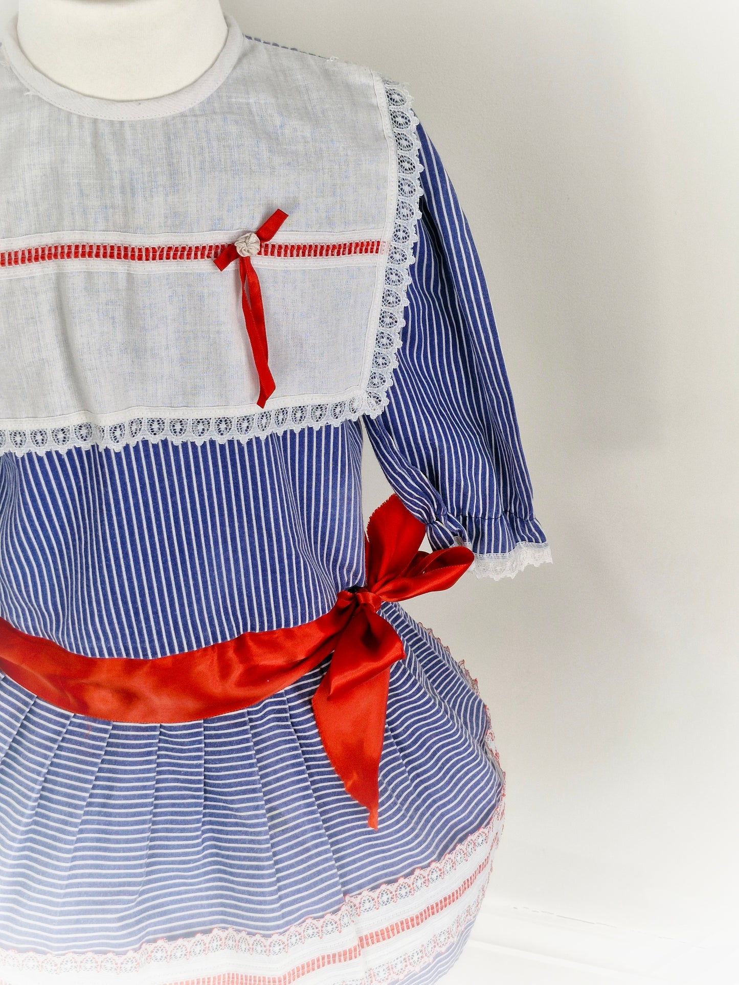 5 years. Blue and white striped vintage Mimix dress, long sleeve with white bib and red ribbon details