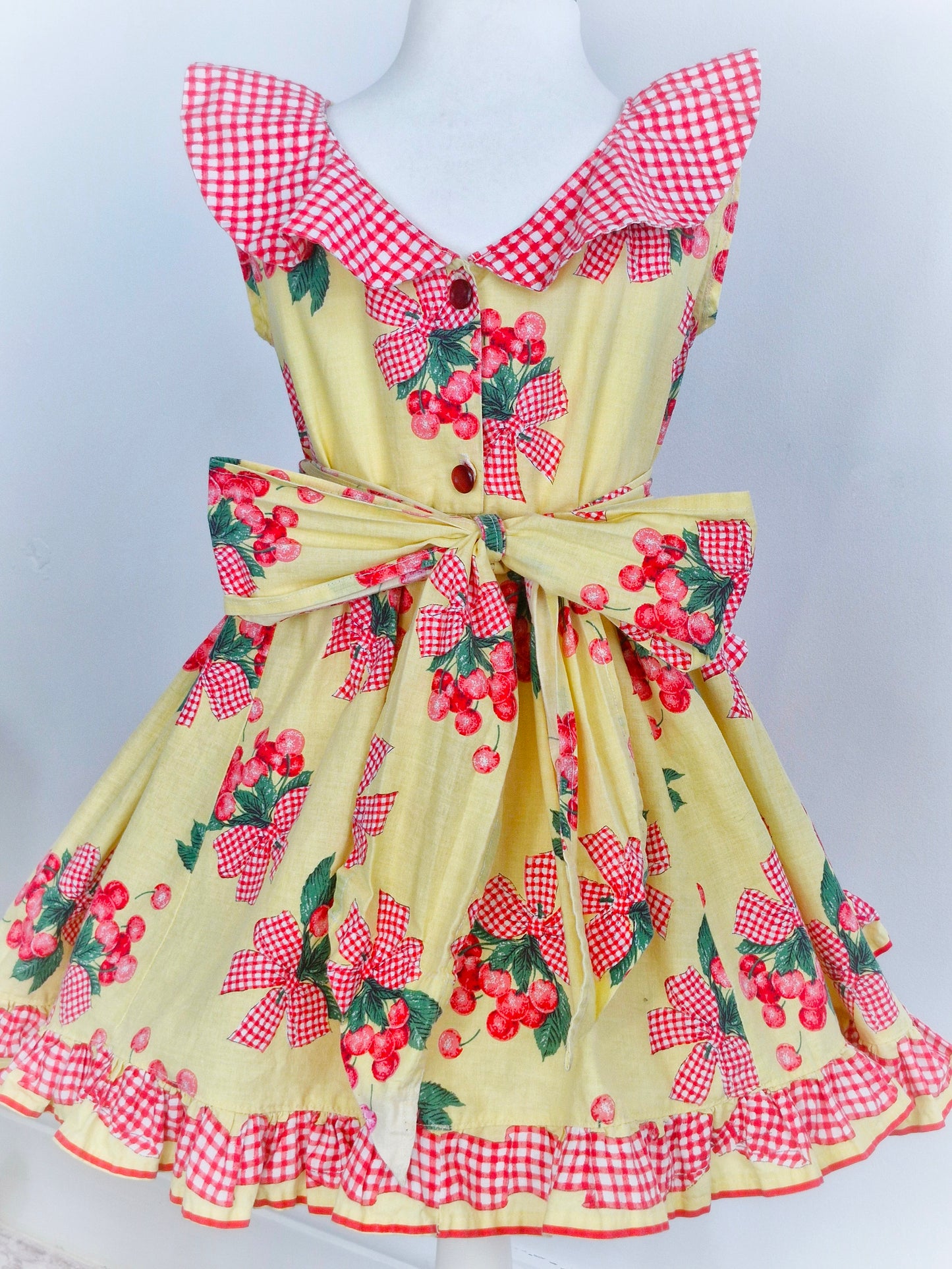 4 years. Handmade from vintage Daisy Kingdom fabric. Lemon dress with cherry print, gingham collar, pockets and trim