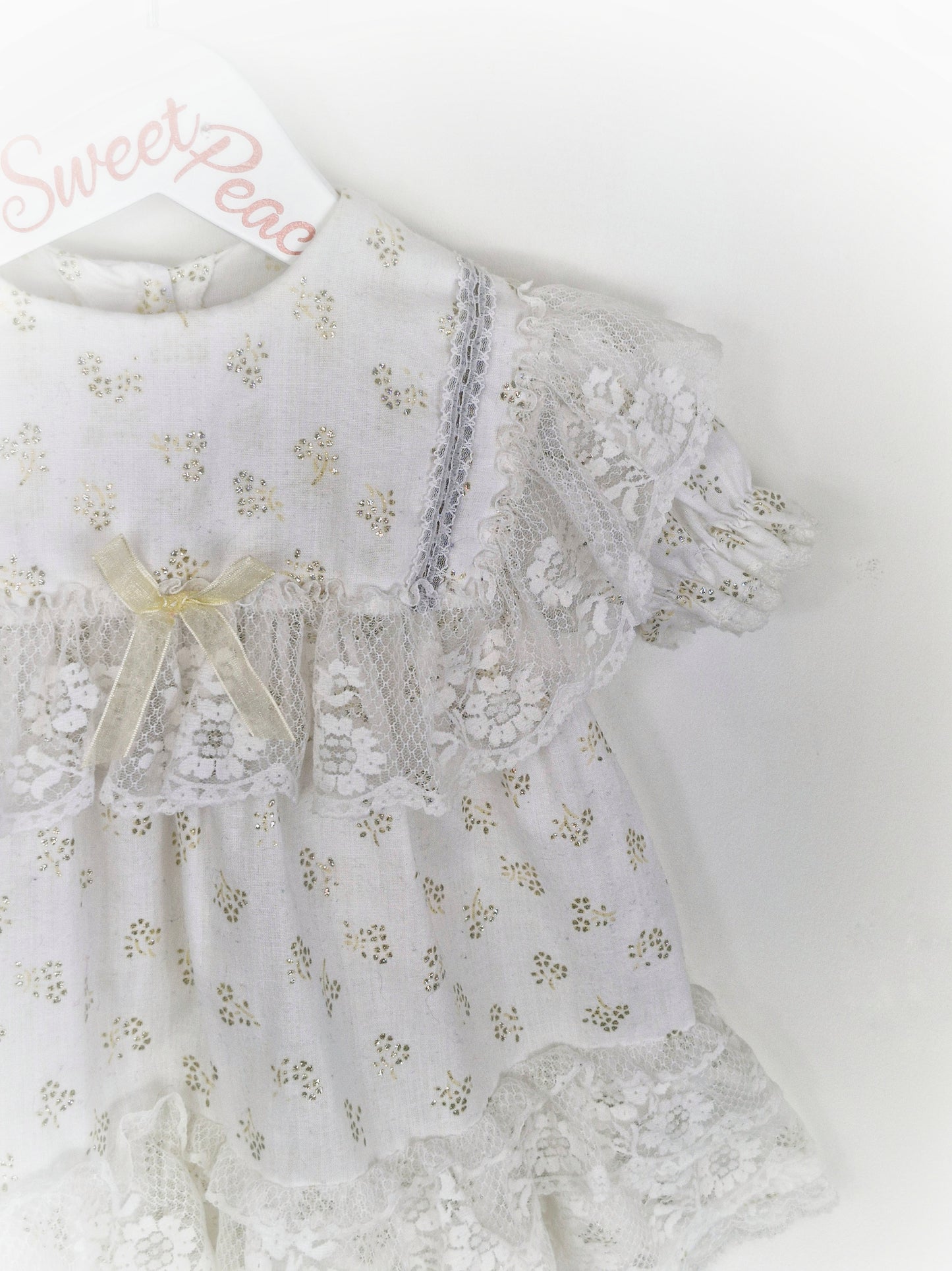 18 months. White dress with lots of lace details and gold glitter patterns