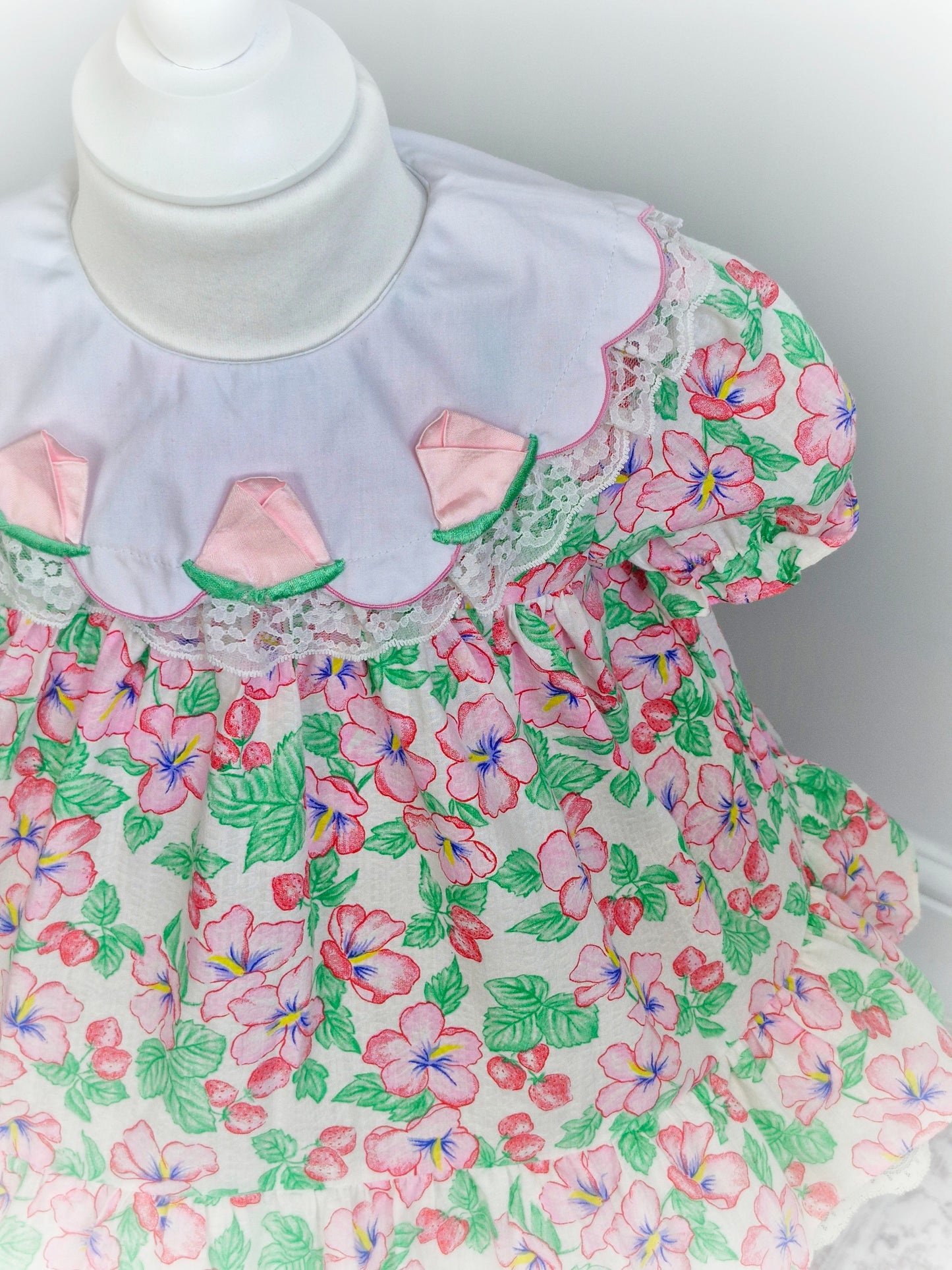 2 years. Strawberry and floral dress with white bib and roses. Lace detail on bib and hem