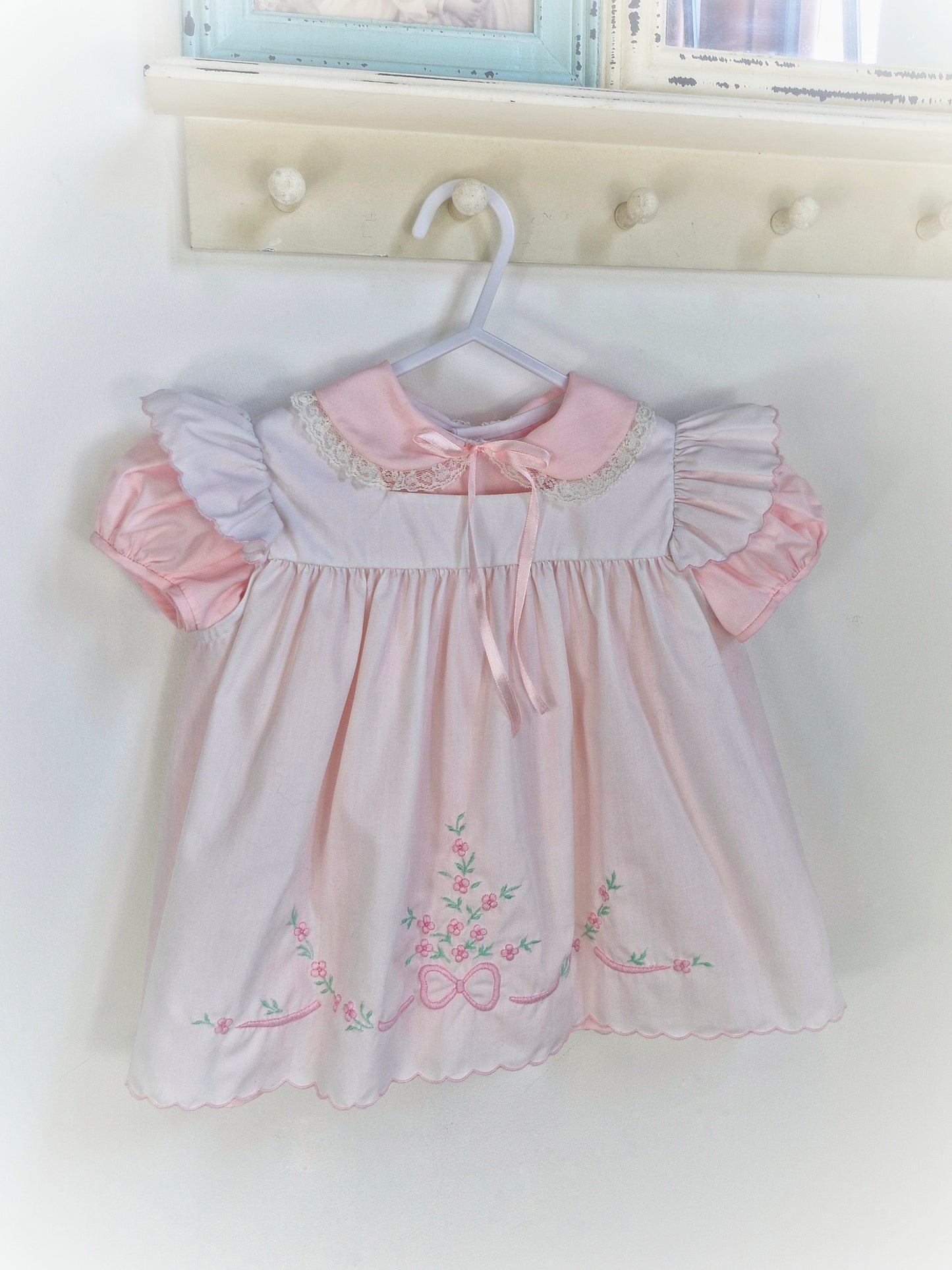 12-18 months. Two piece Nannette vintage pink dress with white pinny embroidered with flowers and bows.