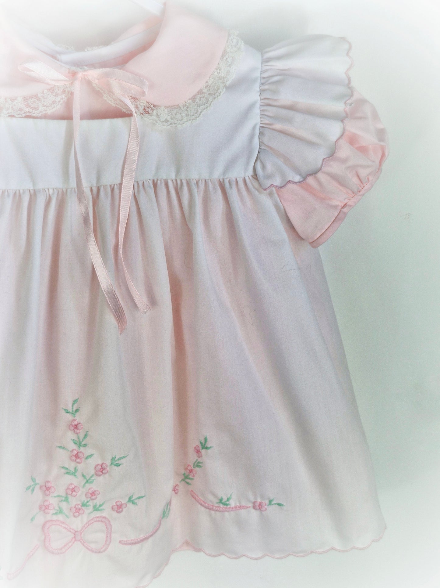 12-18 months. Two piece Nannette vintage pink dress with white pinny embroidered with flowers and bows.