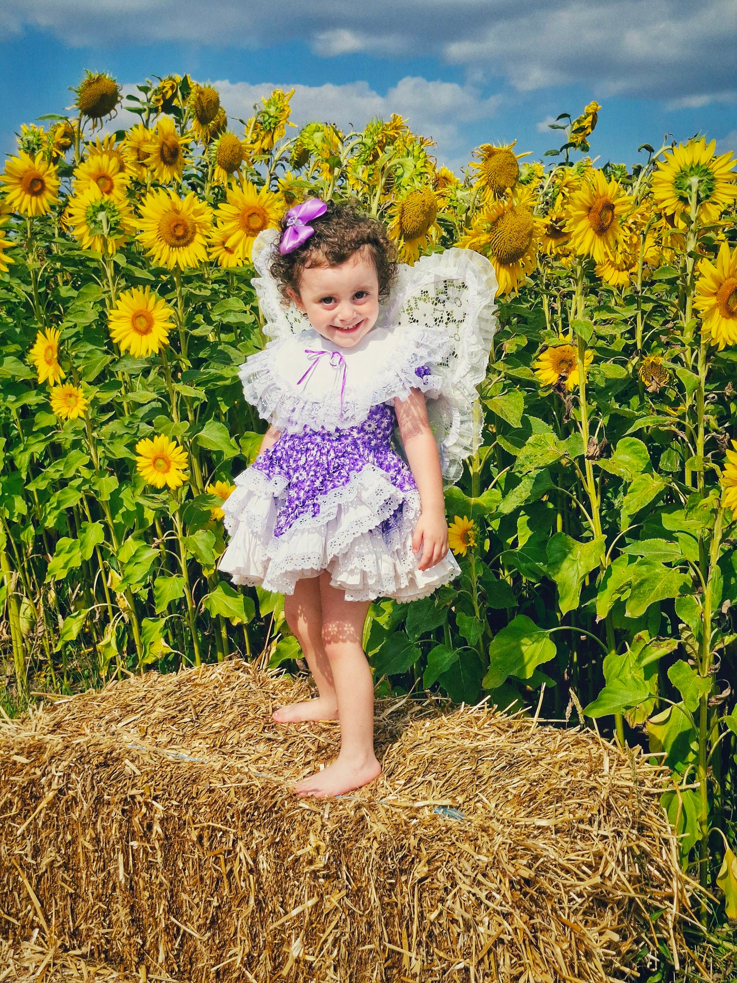 2-3 year. Purple floral Lid'l Dolly with white bib and lace ruffles