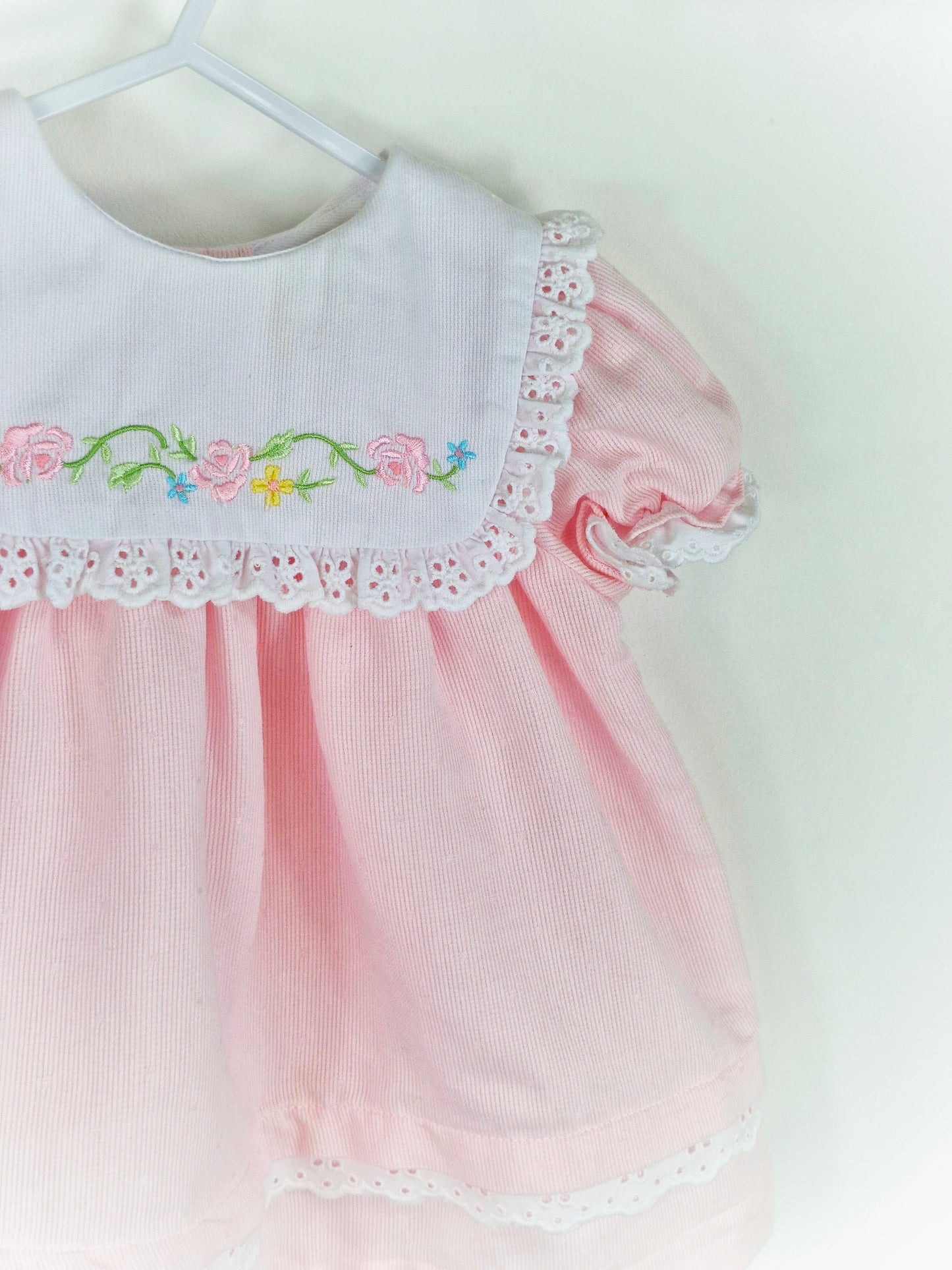 12-18 months. Pink dress with white bib, embroidered with flowers