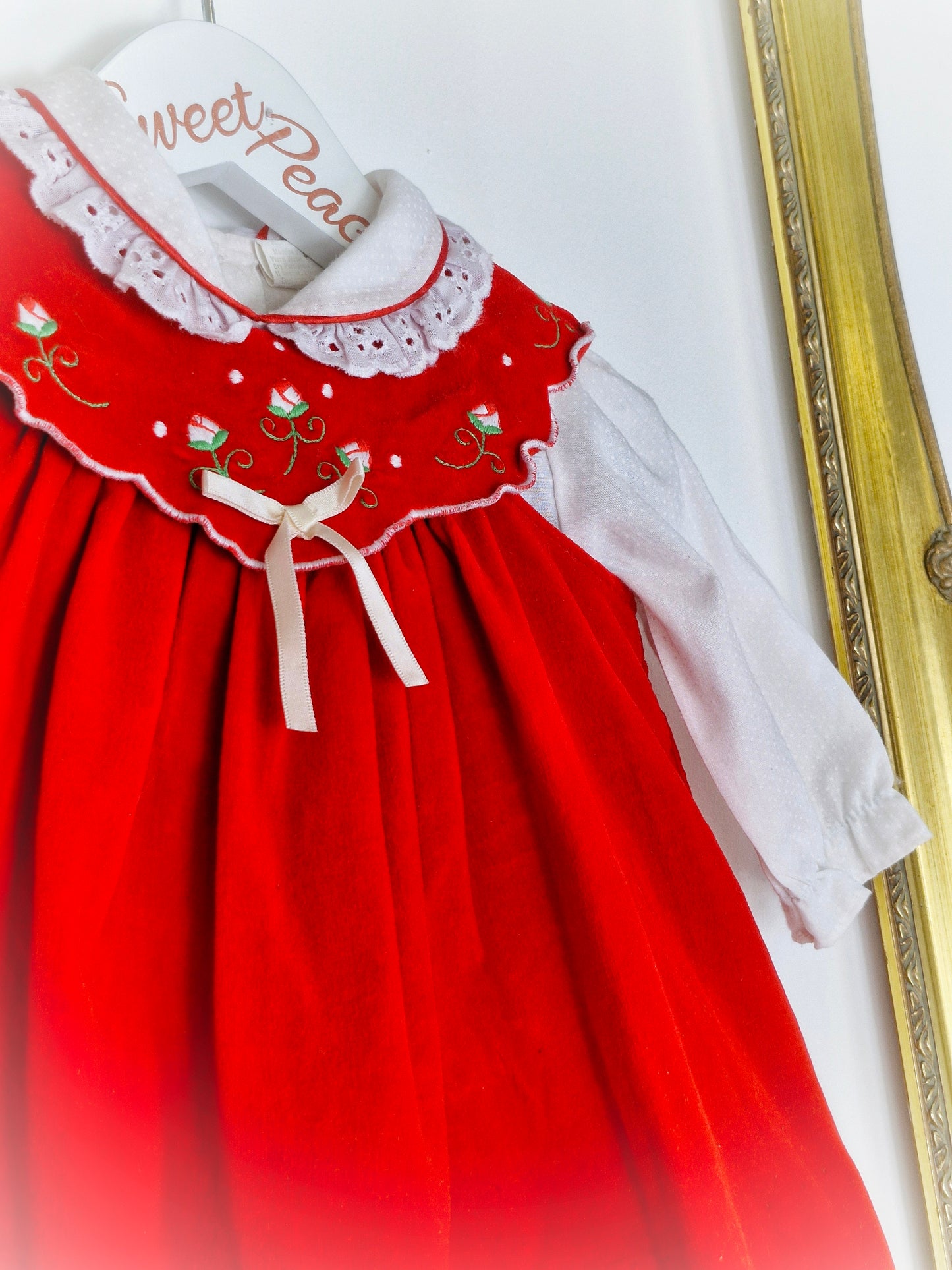 6-9 months. Red velvet dress with white, collared blouse underneath.