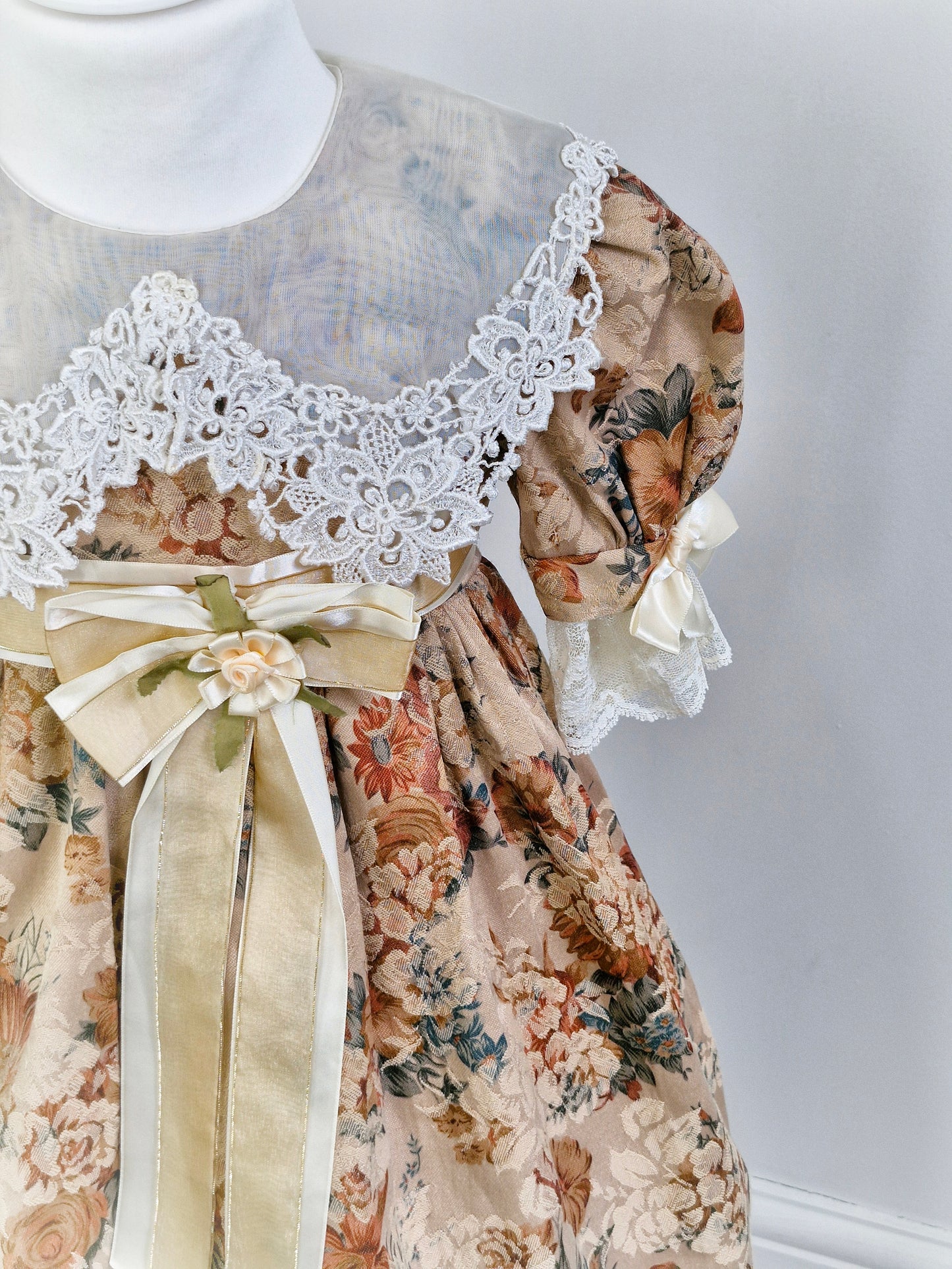 5 years. Large white bib with lace details, sleeves and hem. Floral, puff sleeves and cream waistband
