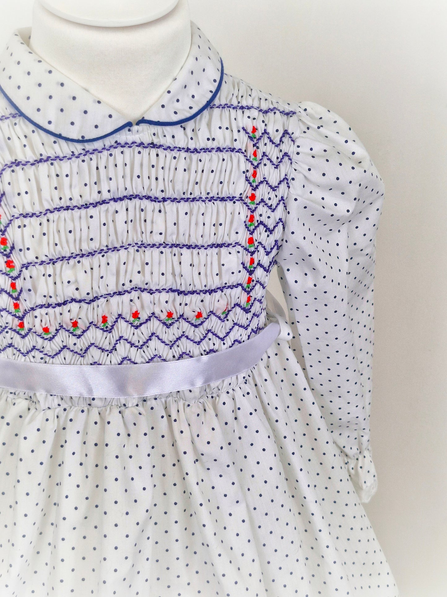 4 years. White Polly Flinders smocked dress with navy polka dots and embroidery