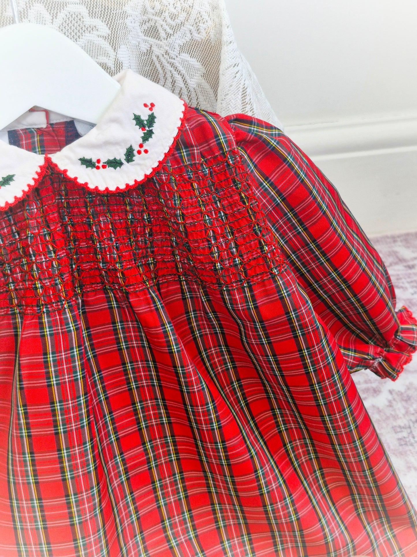 12-18 months. Red tartan dress from Koala Baby with white collar embroidered with holly leaves and smocking