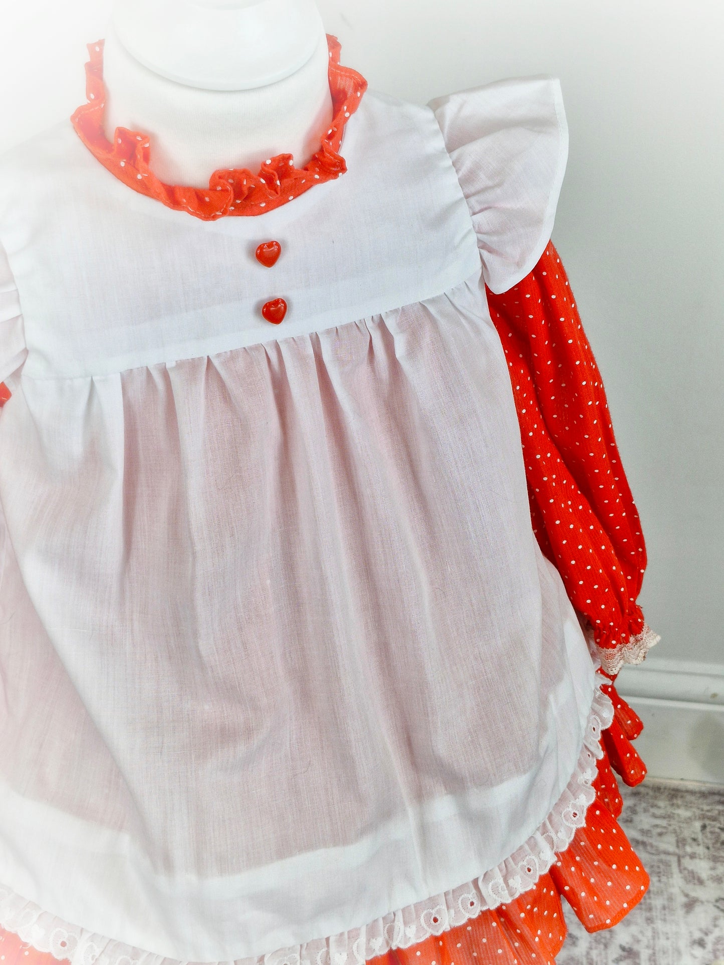 18-24 months. Red polka dot dress with white flutter sleeved pinny