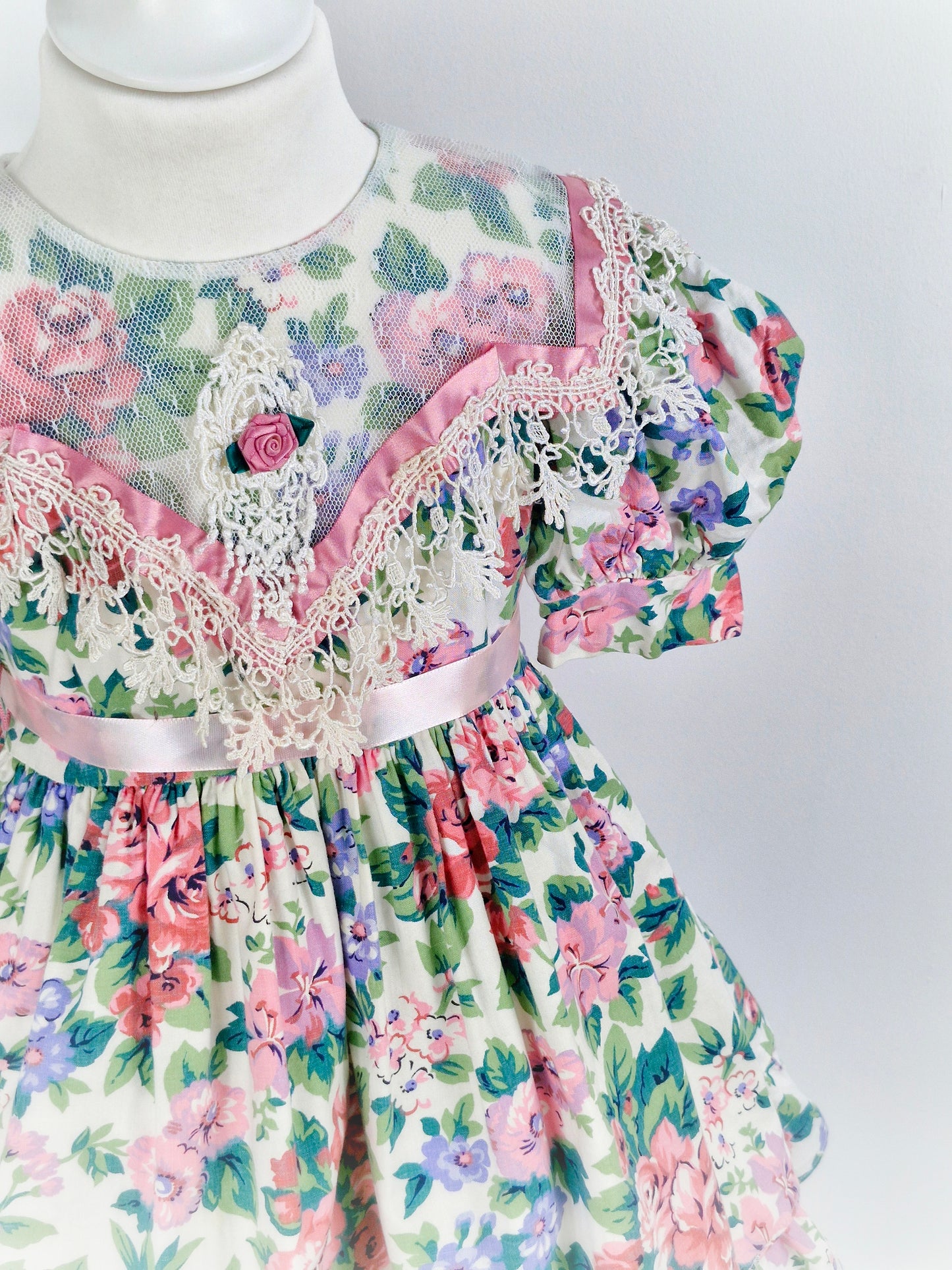 4-5 years. Vintage Jinelle, pastel floral print. Sheer bib, pink ribbon and rosette