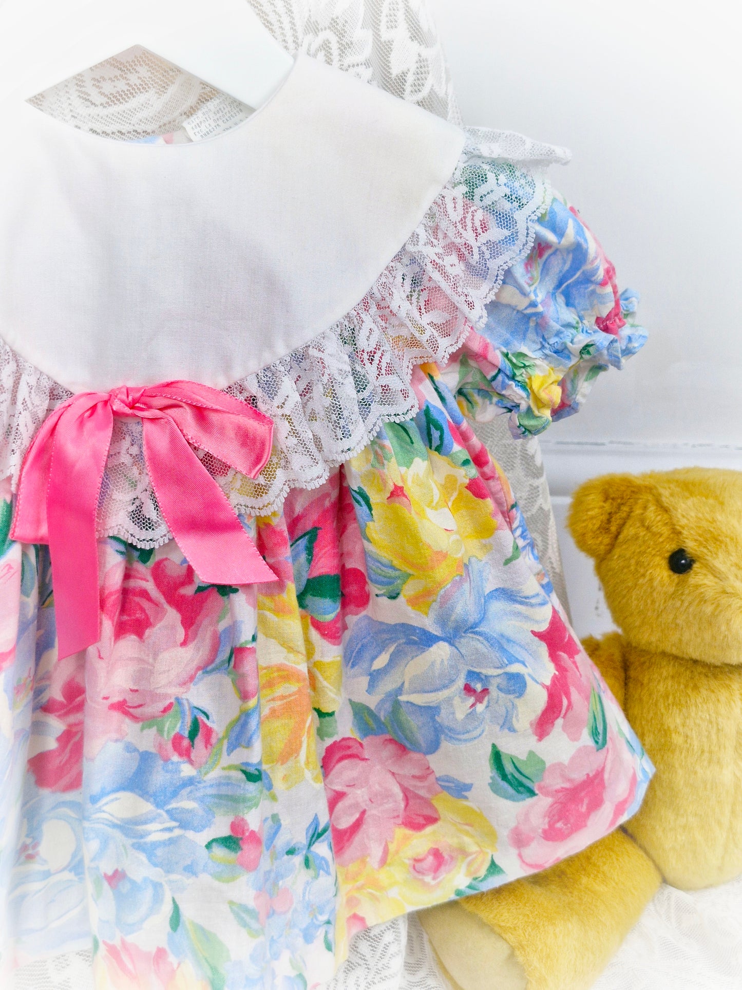 6-9 months. Pastel floral vintage dress with white bib, lace trim and pink ribbon bow
