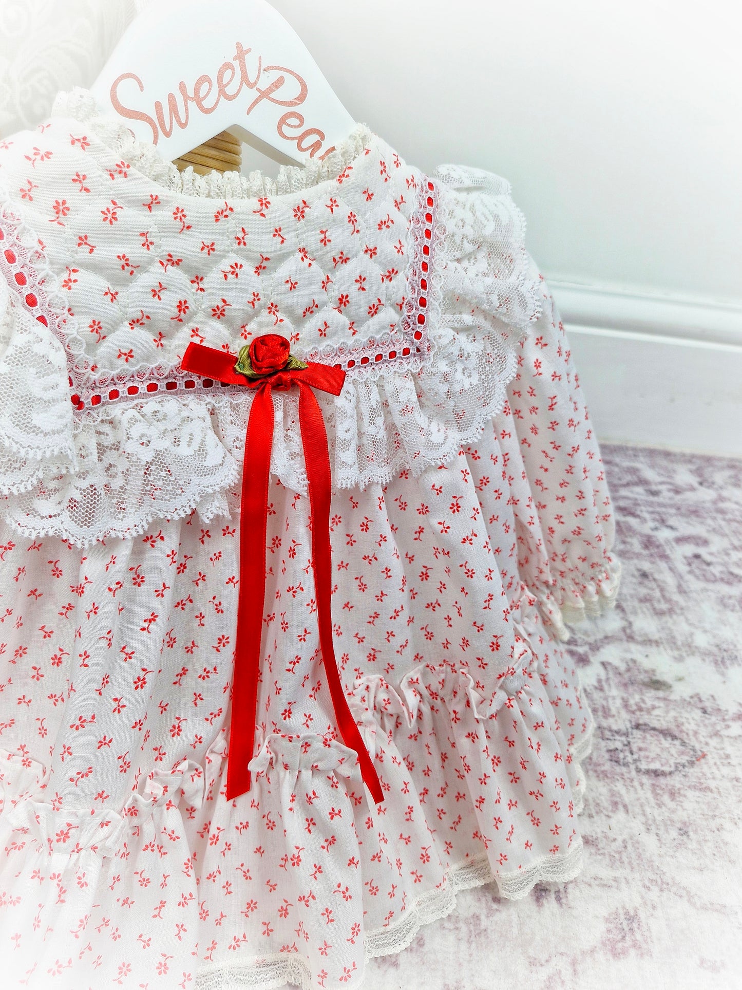 6-12 months. White vintage Bryan with red floral print and ribbon, white lace