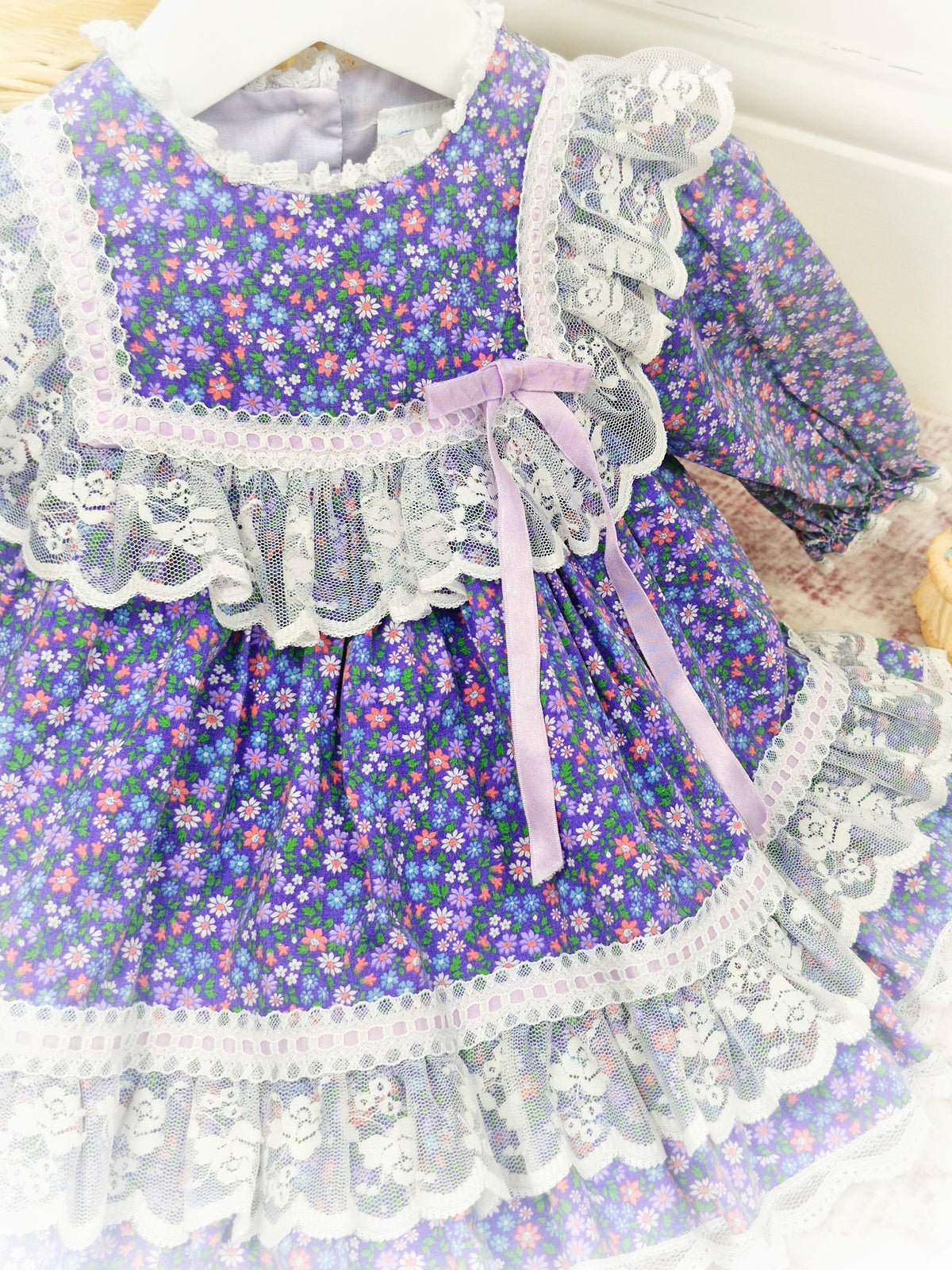 12 months. Purple floral vintage dress by Bryan with white lace details and lilac satin ribbon