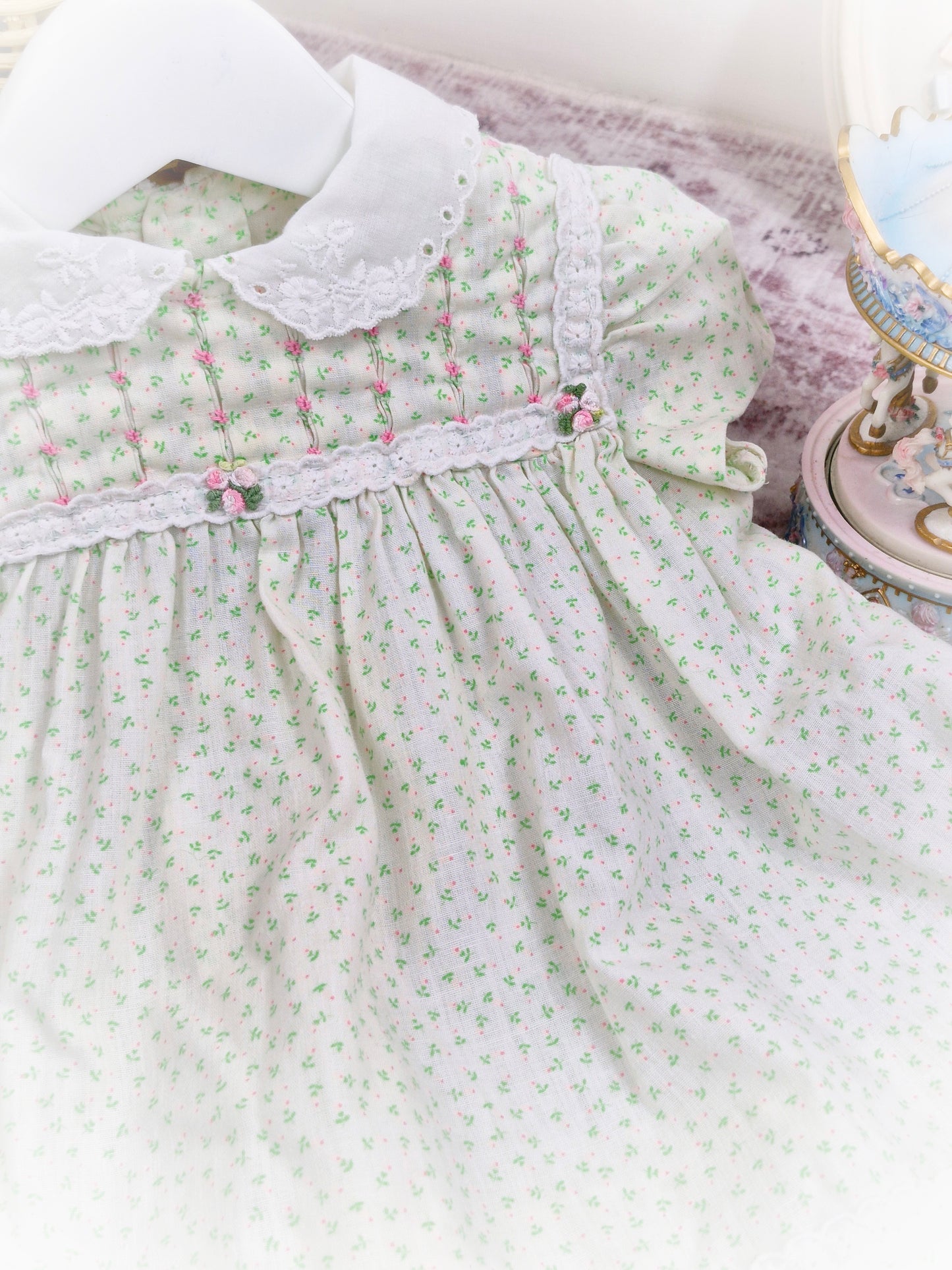12-18 months. Cream vintage Polly Flinders dress with green and pink print, smocking with pink embroidered flowers and white collar