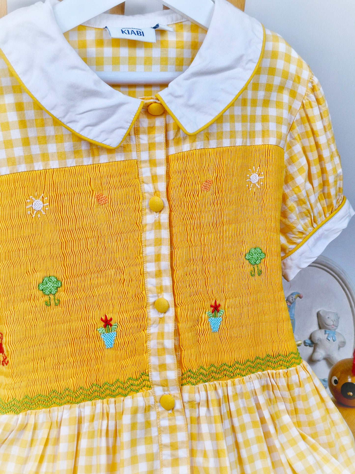 9-10 years. Yellow and white button down gingham smock dress with embroidered patterns
