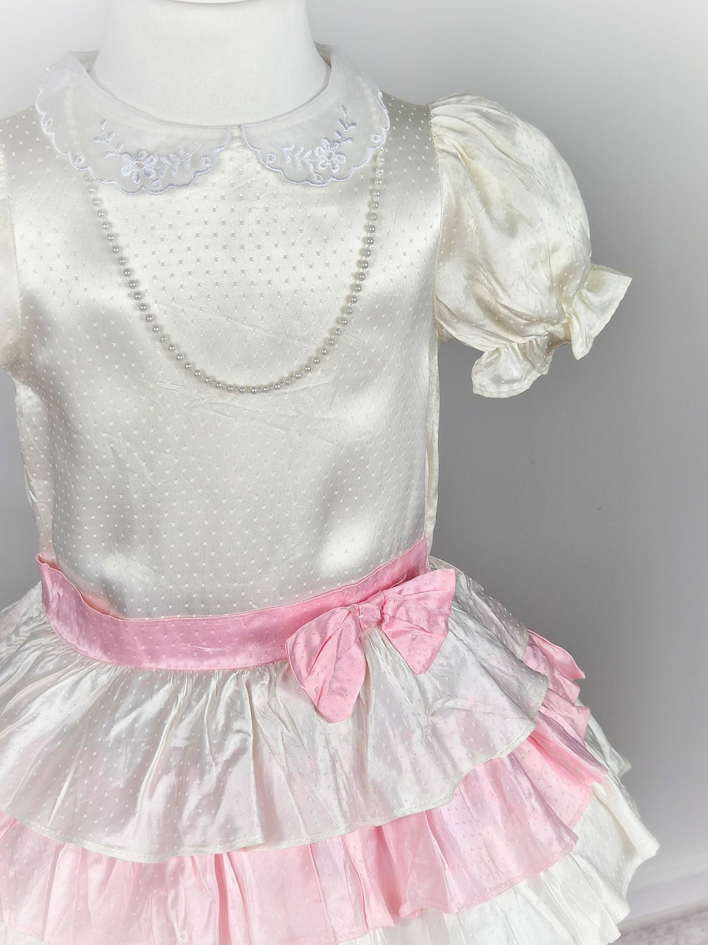 3 years. White satin drop waist vintage dress with pink bow and layers, puff sleeves and pearl faux necklace