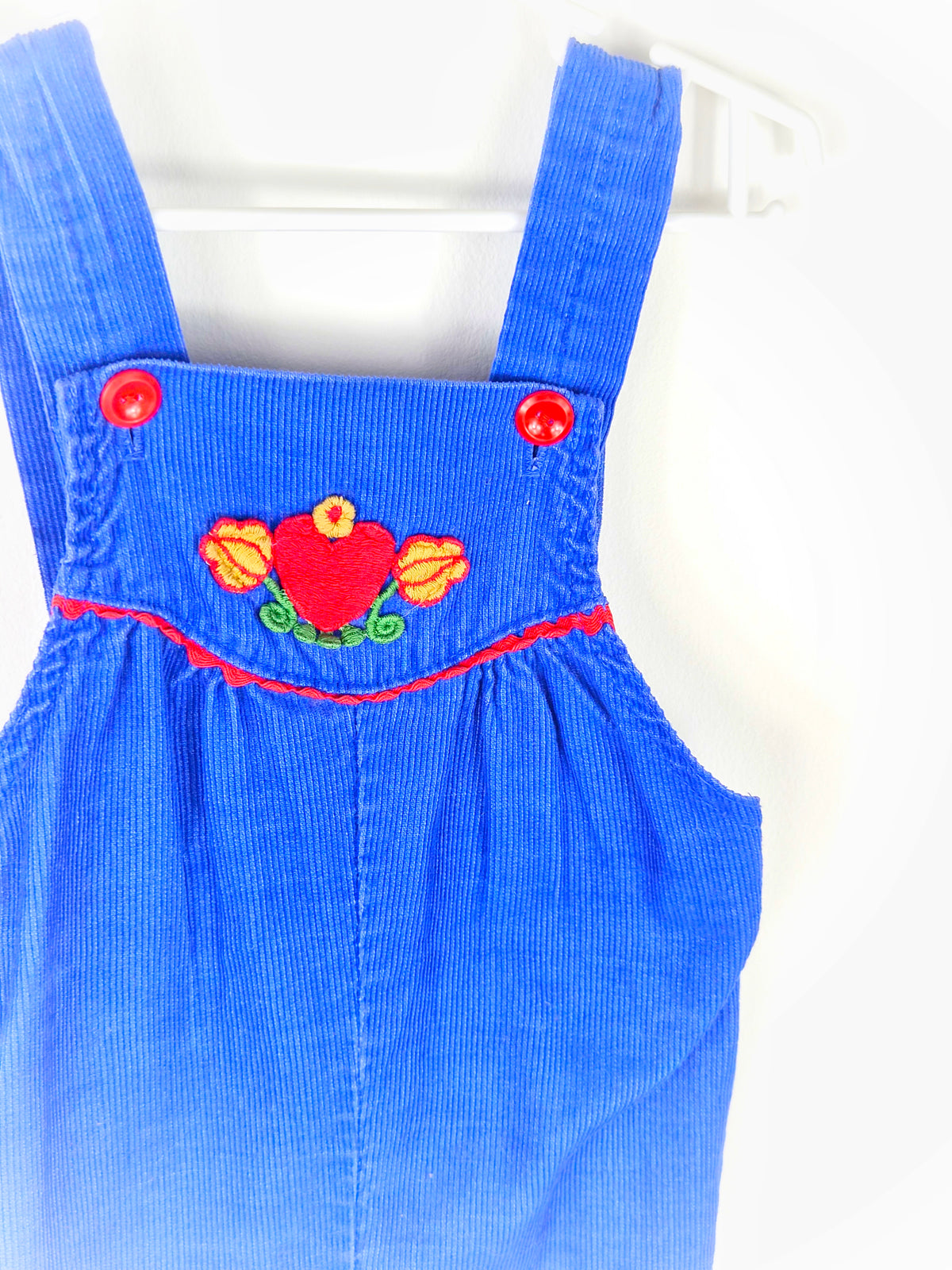 12-18 months. Royal blue corduroy dungarees with red buttons and heart and floral pattern