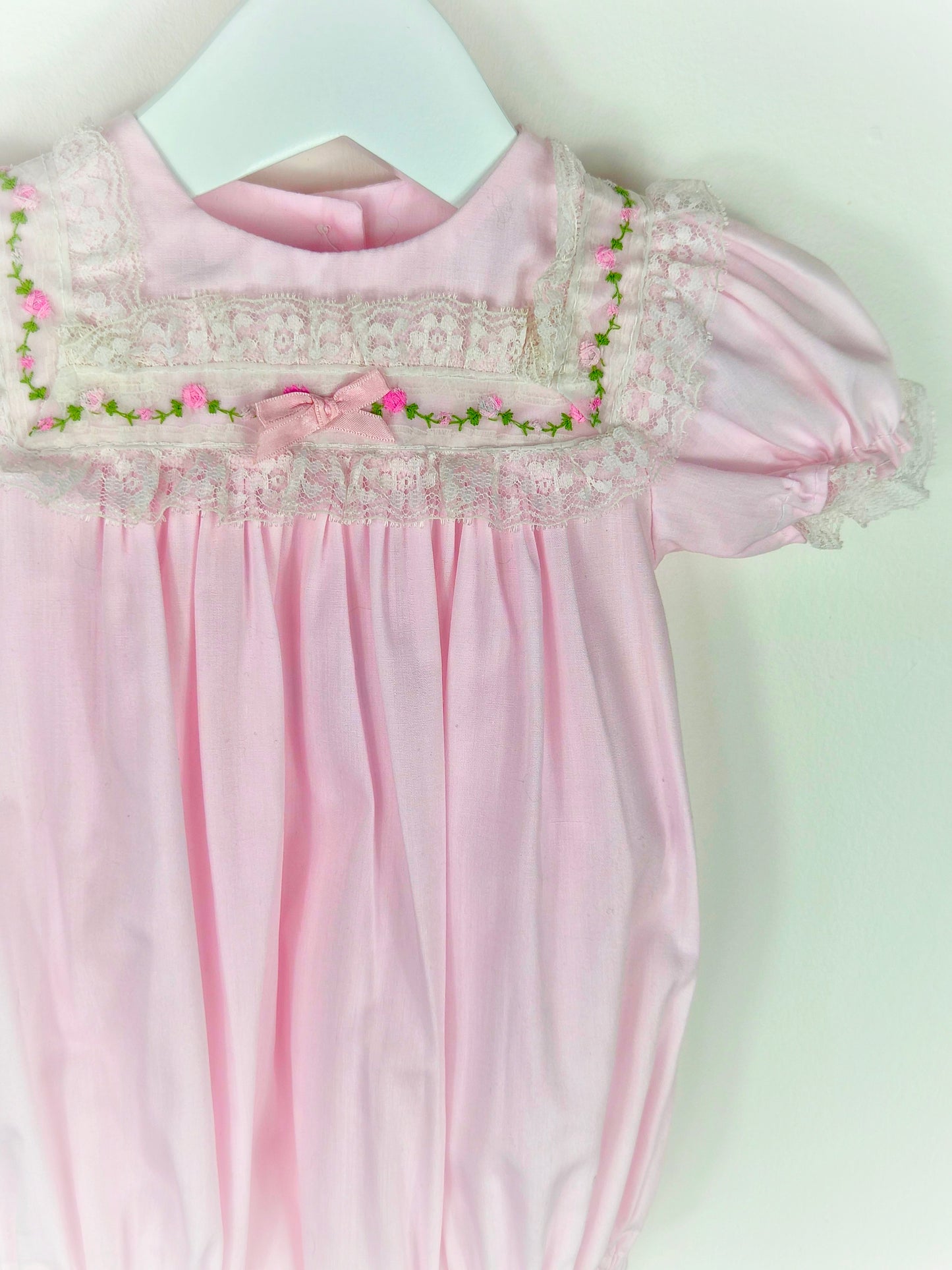 9 months. Pink vintage Alexis romper with puff sleeves and embroidered flowers on a lace bib