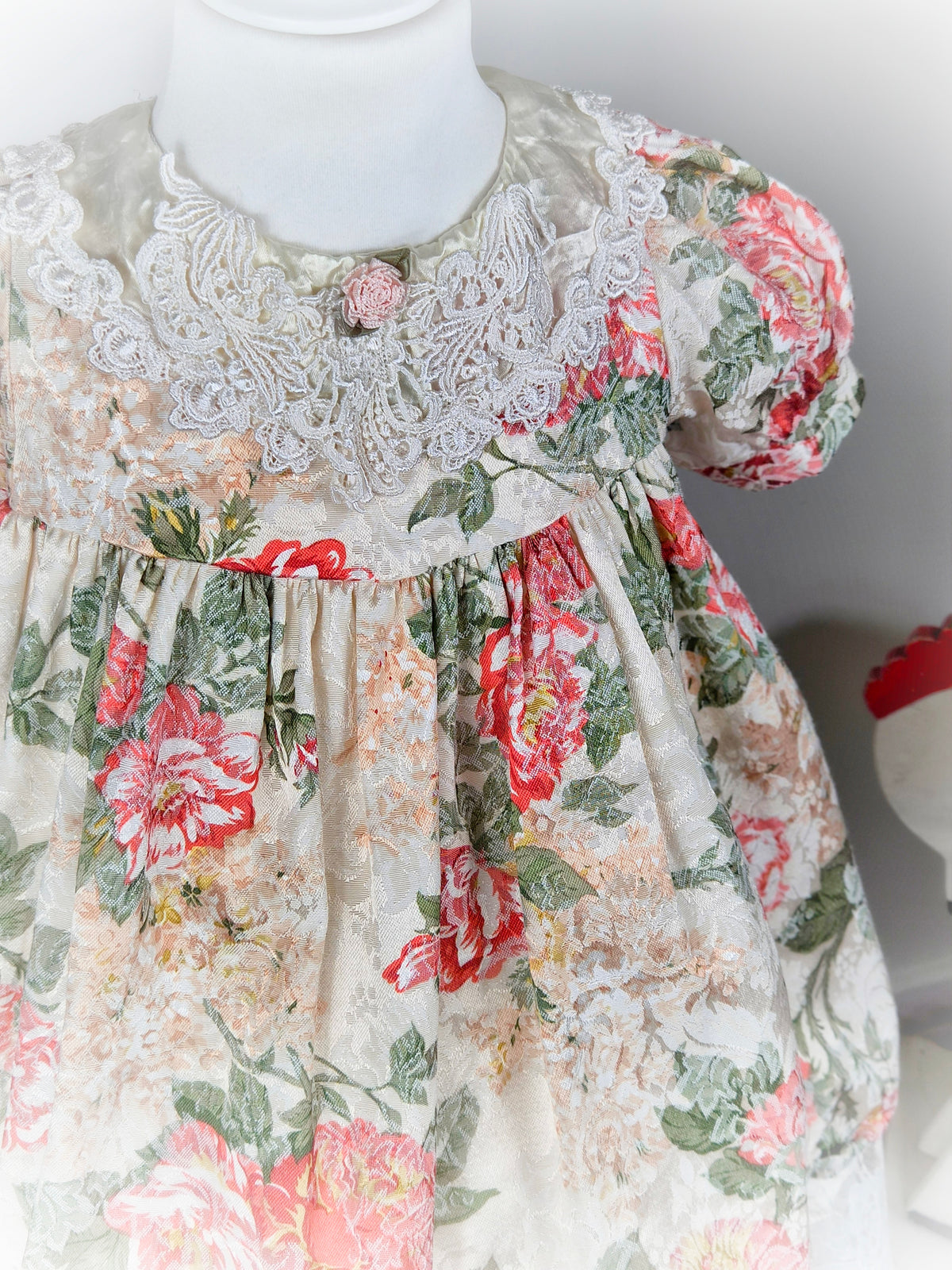 3 years. Cream vintage floral dress with puff sleeves, satin and lace bib and pink rosette