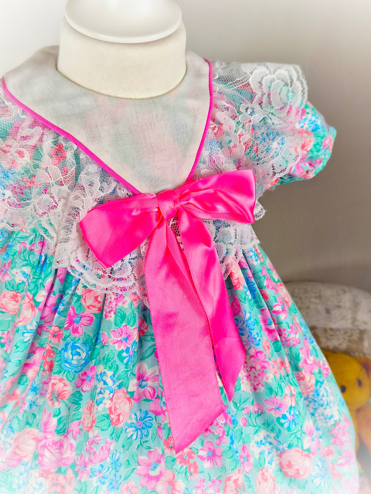 18-24 months. Bright floral vintage dress with white bib and large hot pink satin bow