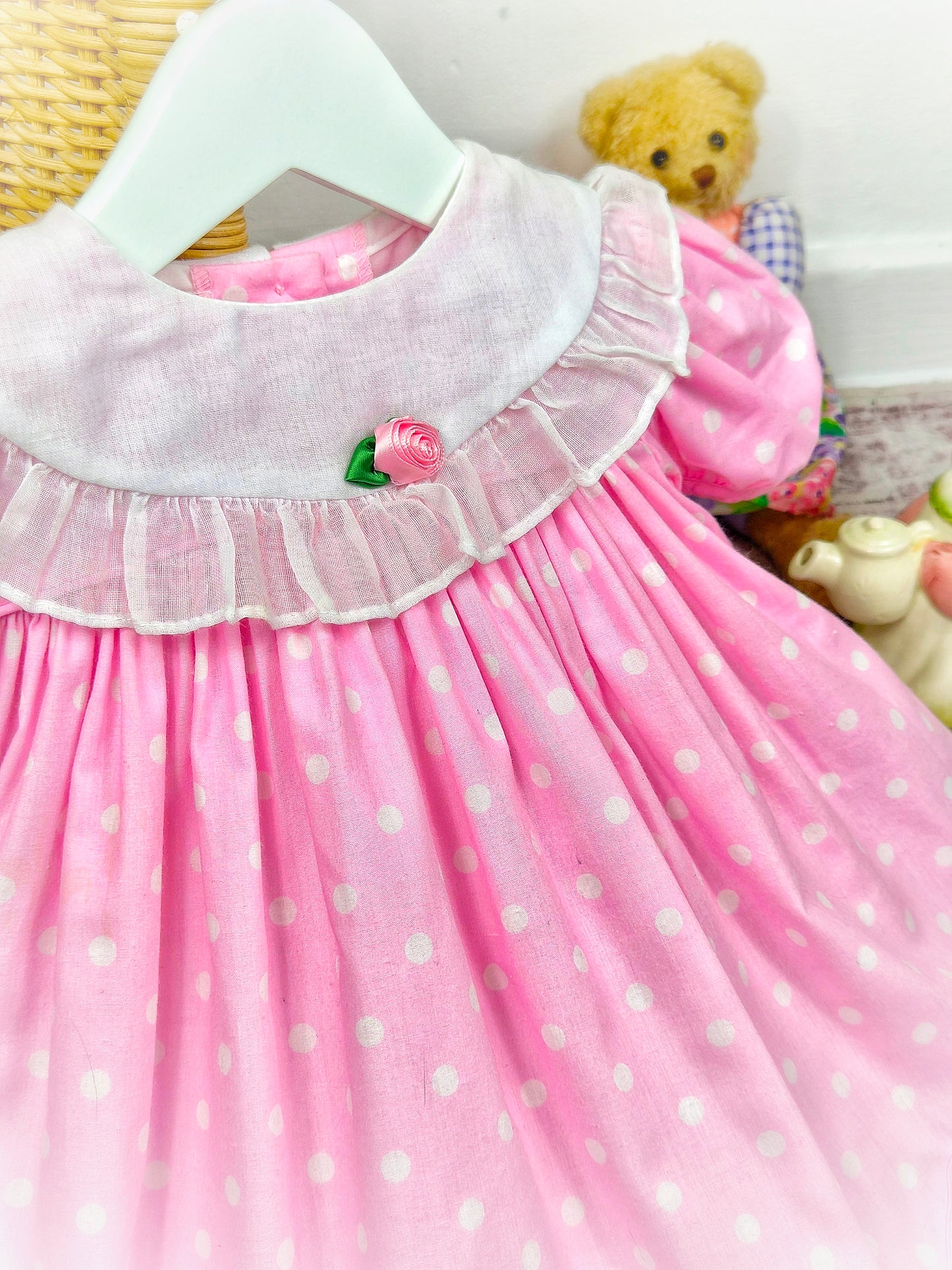 9-12 months. Pink vintage dress with white polka dots, bib, puff sleeves and rosette. Ruth of Carolina