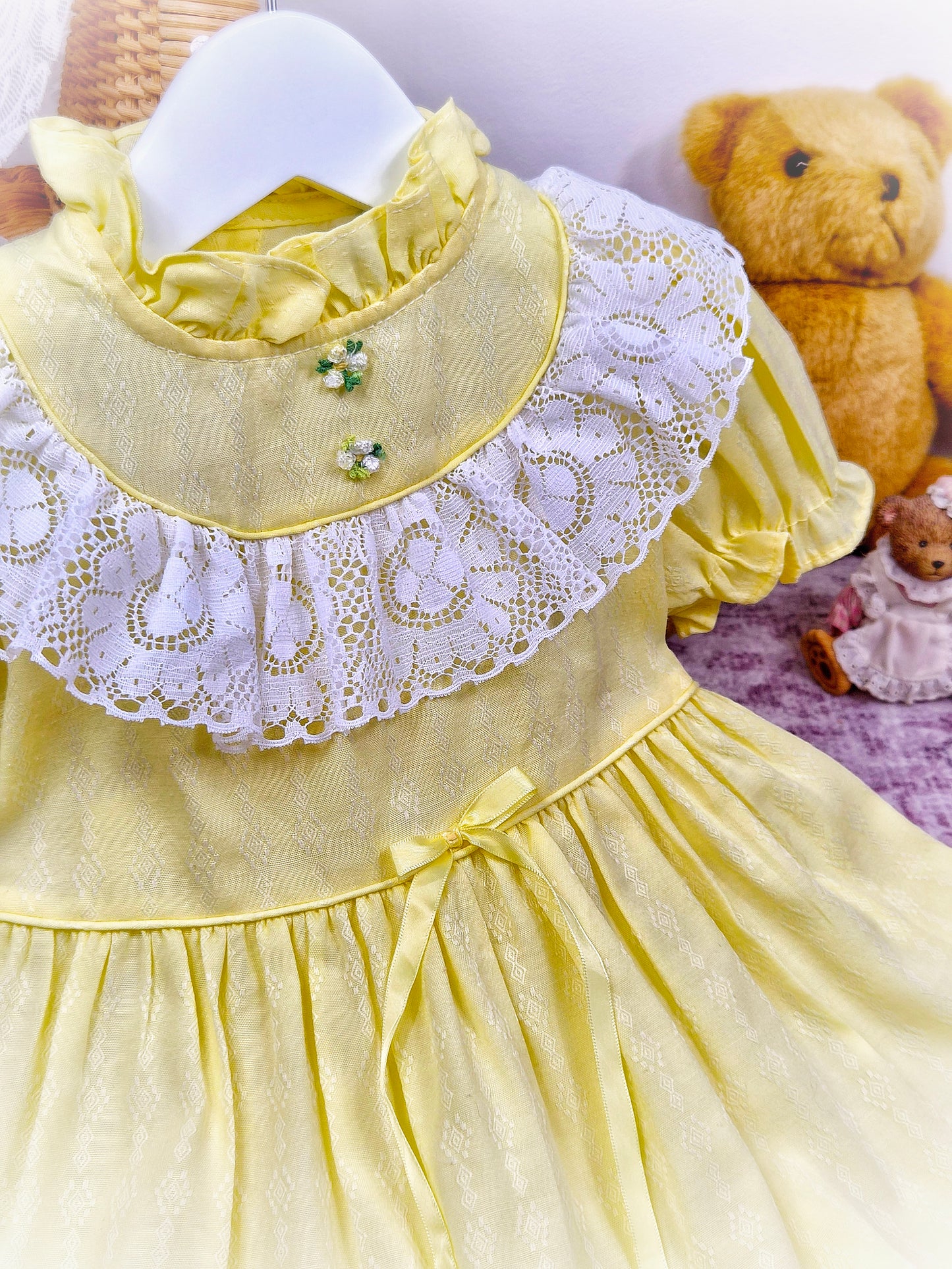 12-18 months. Lemon vintage dress by Toddle Time with white lace details across chest, ruffle neck and puff sleeves