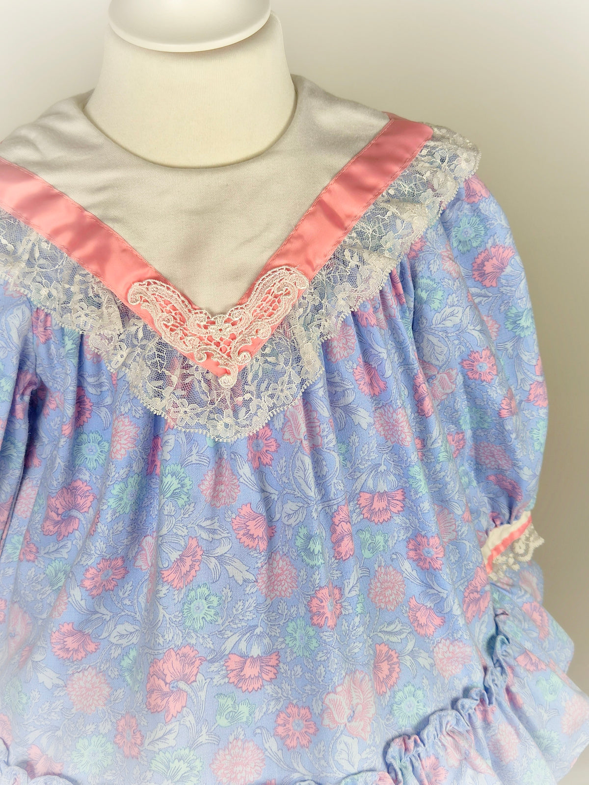 2-3 years. Vintage Polly Flinders dress with floral print, white lace trimmed bib and pink satin ribbon