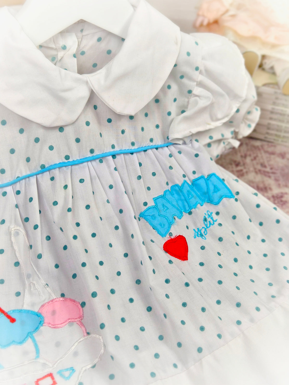 9-12 months. White vintage dress with blue polka dots, white peter pan collar and "banana split"