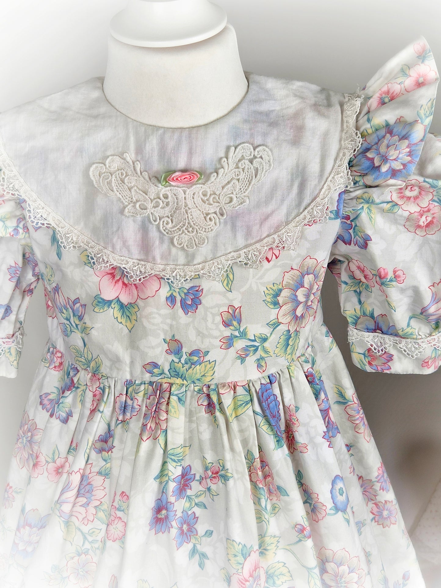 4-5 years. White vintage dress with floral design, puff sleeves, large bib and rosette