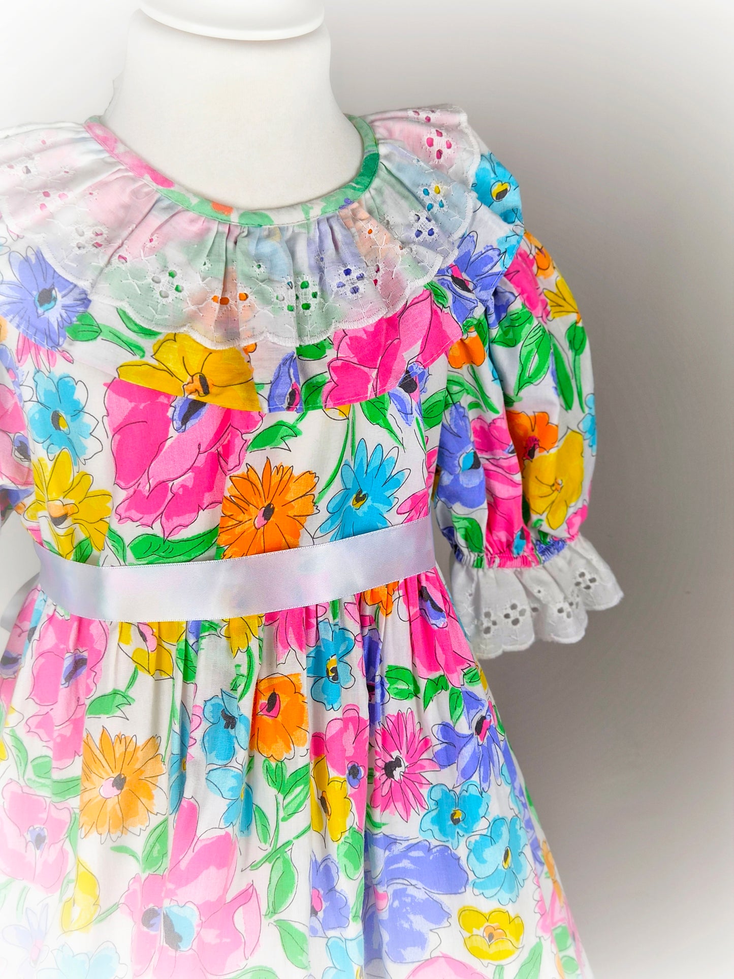 7-8 years. Pretty floral vintage dress with white eyelet collar and hem and puff sleeves