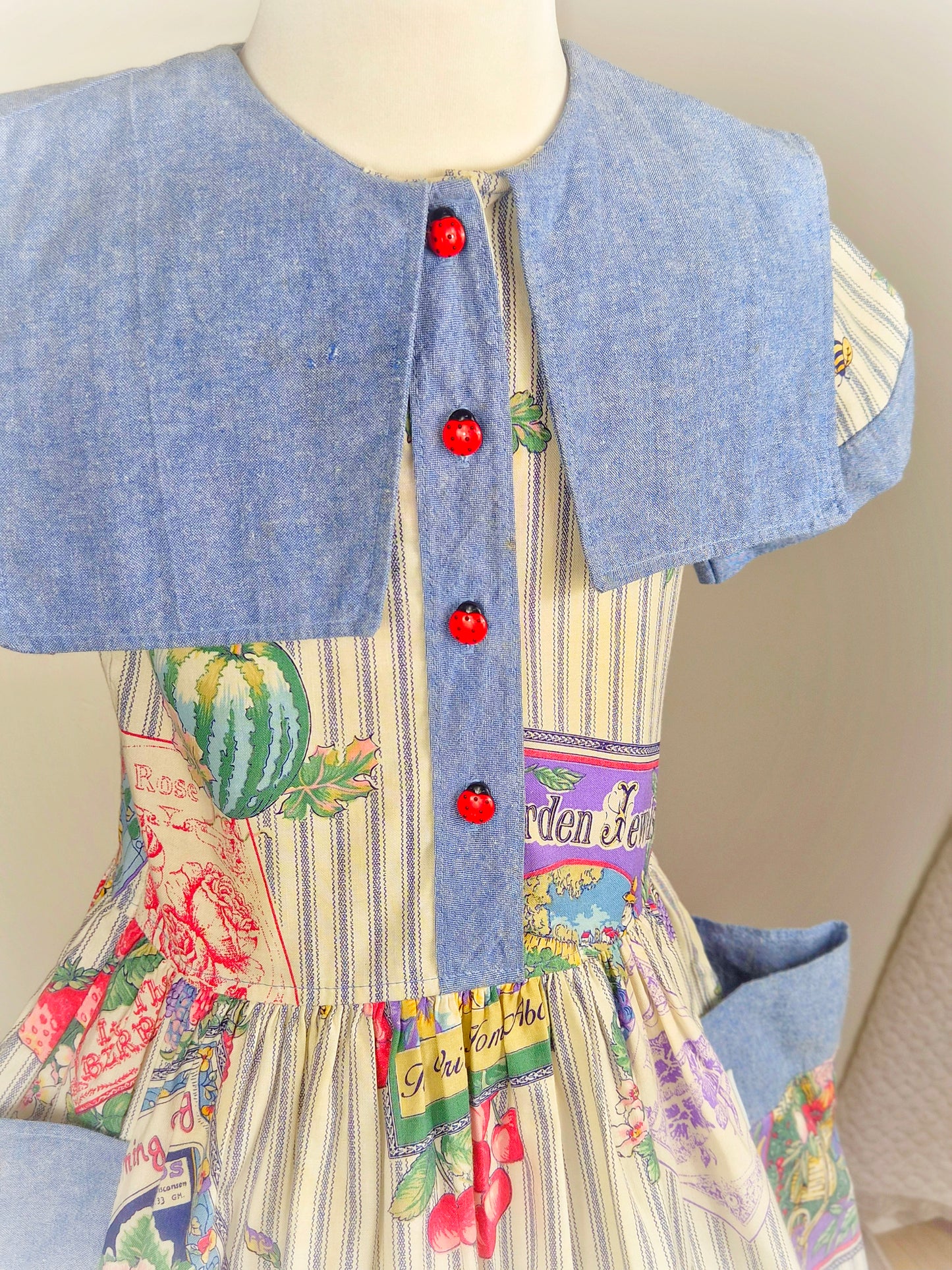 6 years. Vintage dress with fruit and floral print, denim collar and pockets and cute ladybug buttons