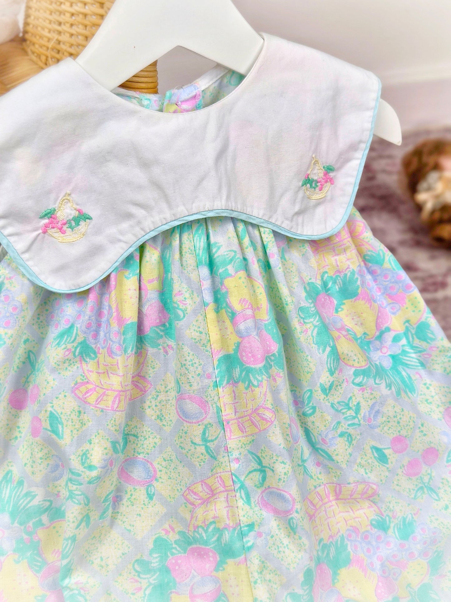 9-12 months. Vintage sleeveless romper by Prenatal with pastel fruit print, white bib and embroidered fruit basket