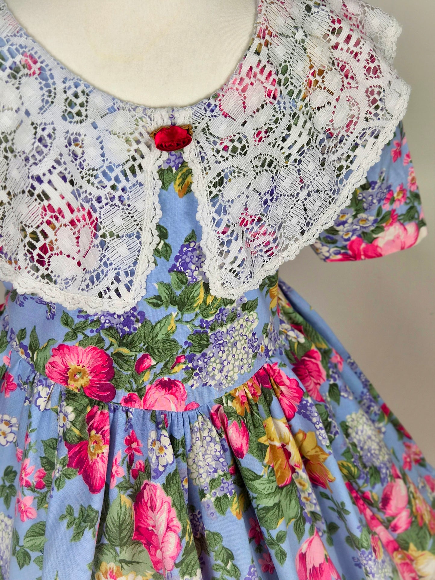 3-4 years. Blue vintage dress with floral design and large white lace bib