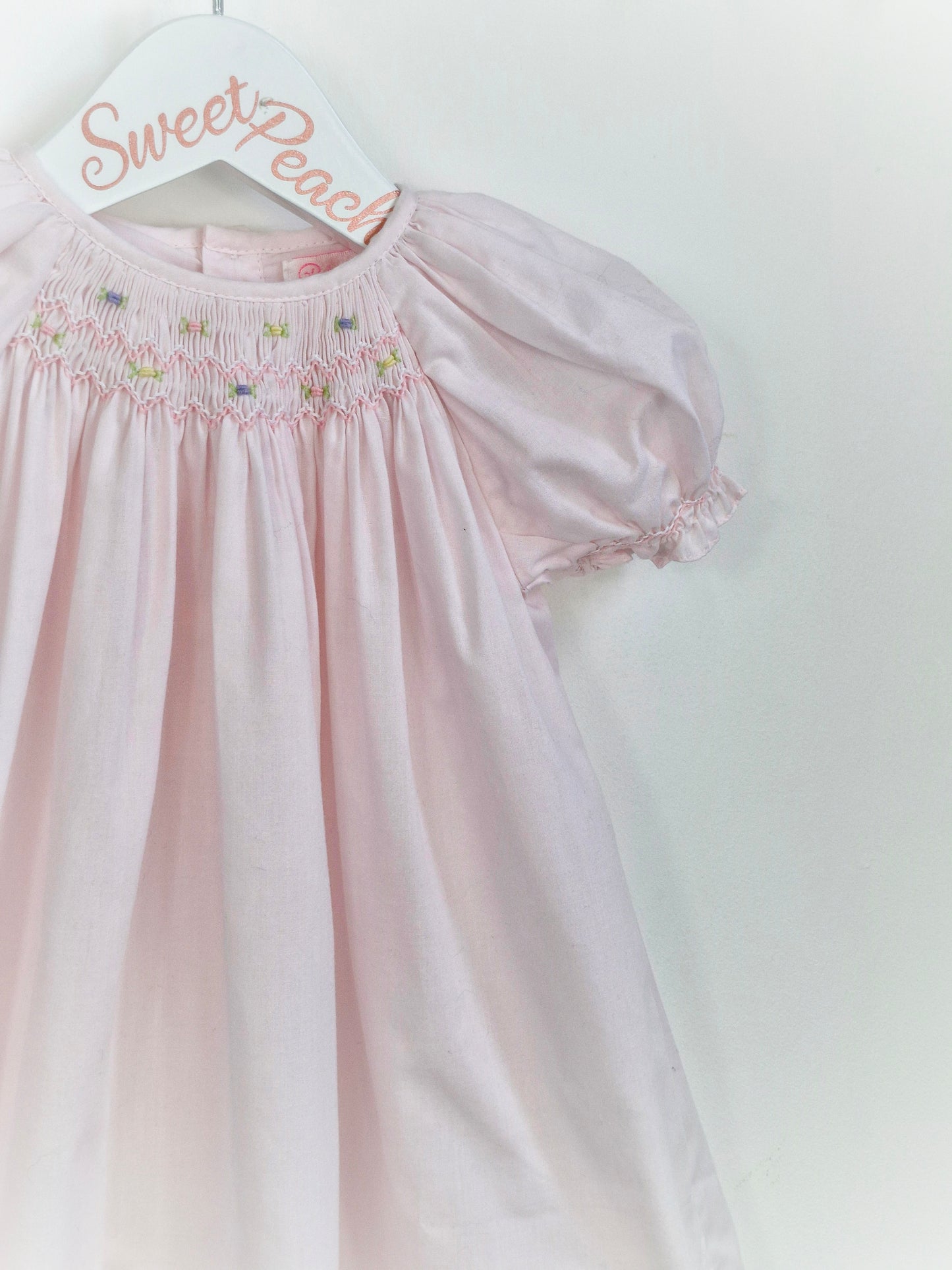 12 months. Petit Ami, pale pink gown with smocking and embroidery neckline