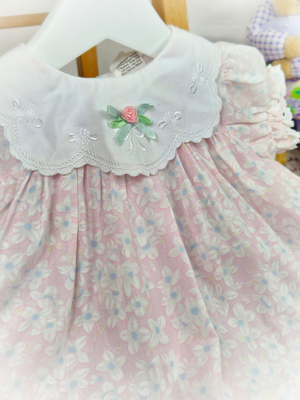 9-12 months. Pink and white floral vintage dress with embroidered details on the bib