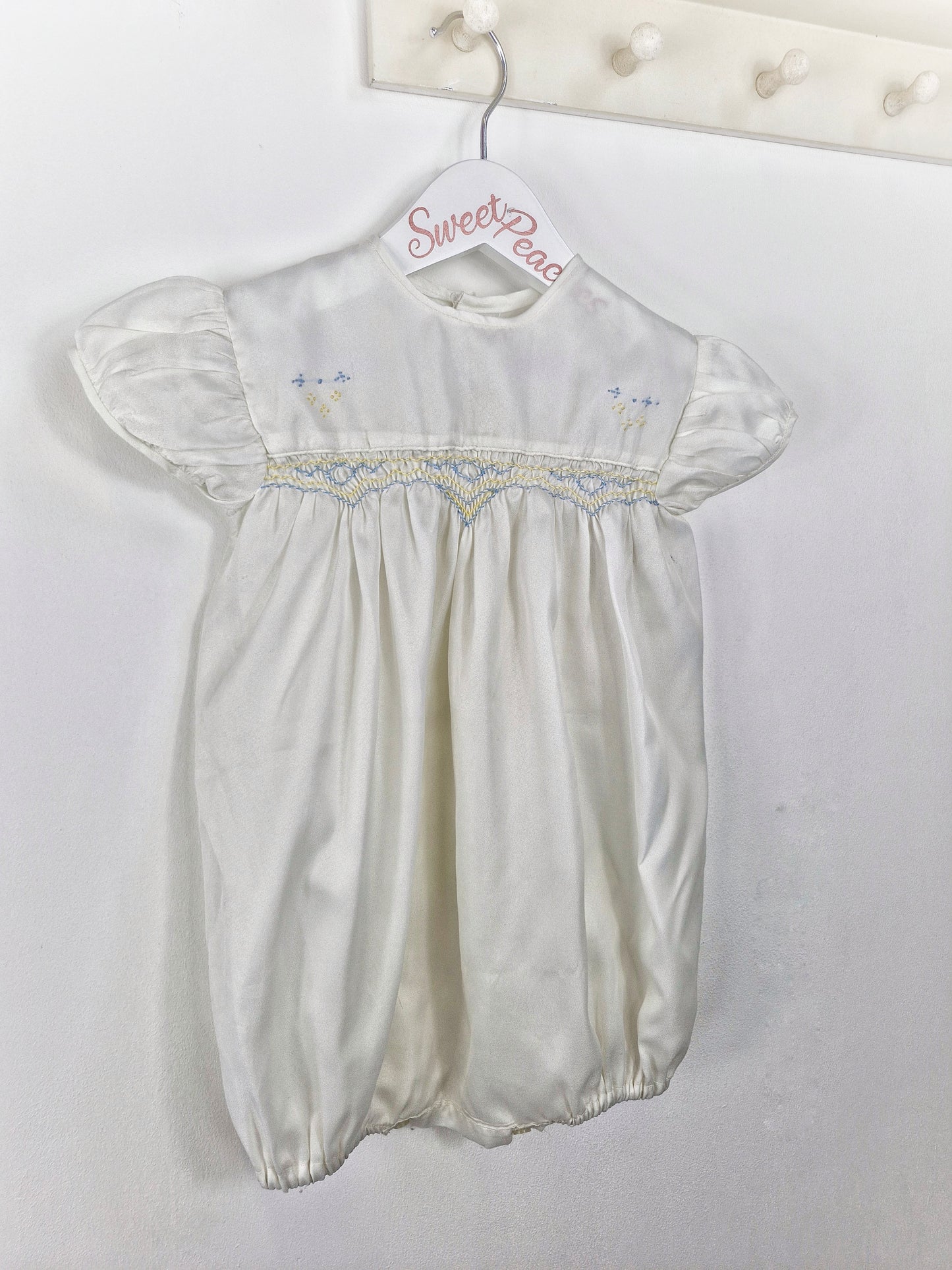 Best fit 2-3 years. Ivory satin unisex romper with lemon and blue smock embroidery