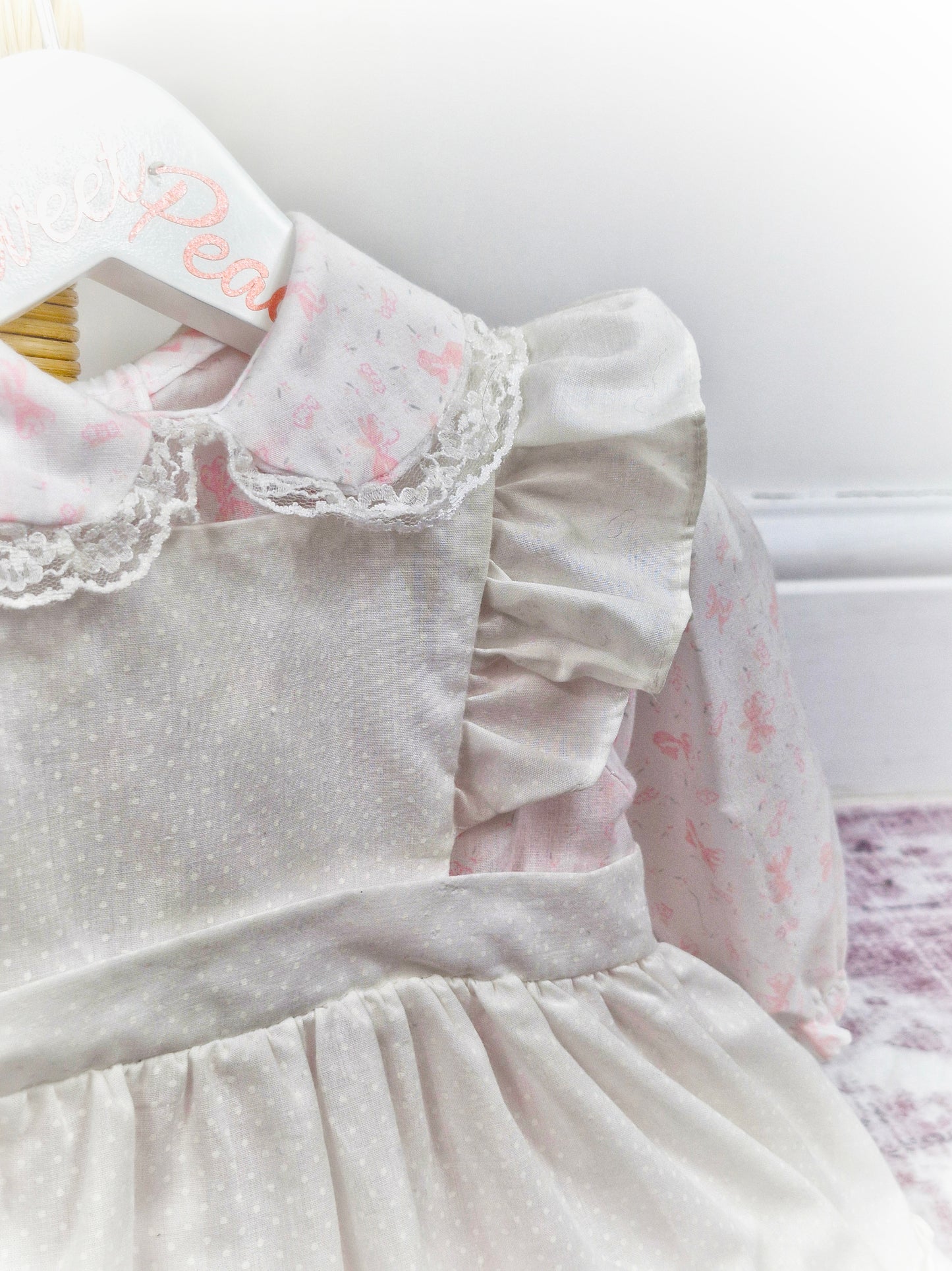 12-18 months. White dress with pink bows print and white pinny, embroidered with flowers