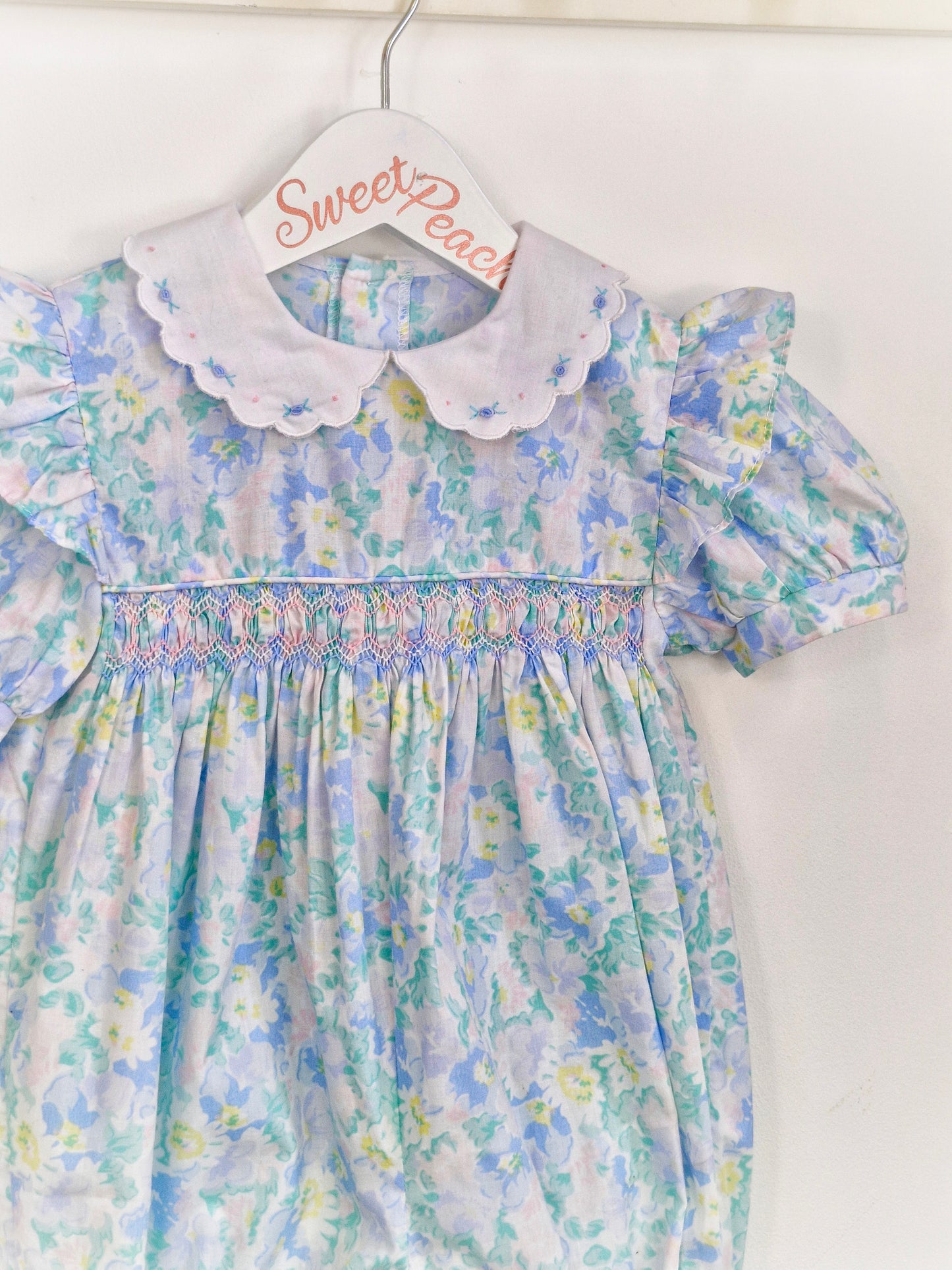 12-18 months. Blue, floral, smocked romper with white, embroidered collar
