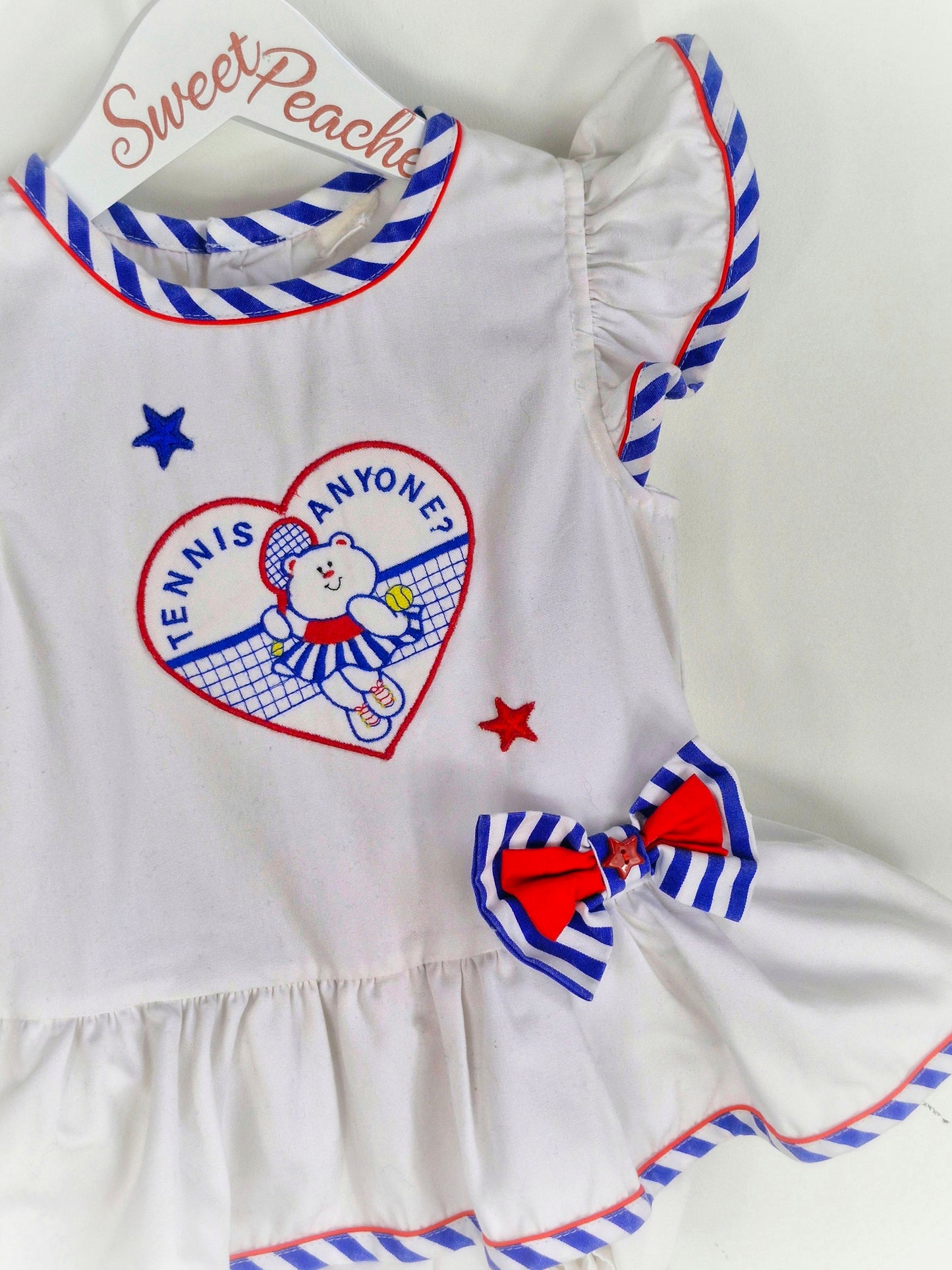 18-24 months. White vintage romper with blue and red details, embroidered teddy bear and "tennis anyone?"