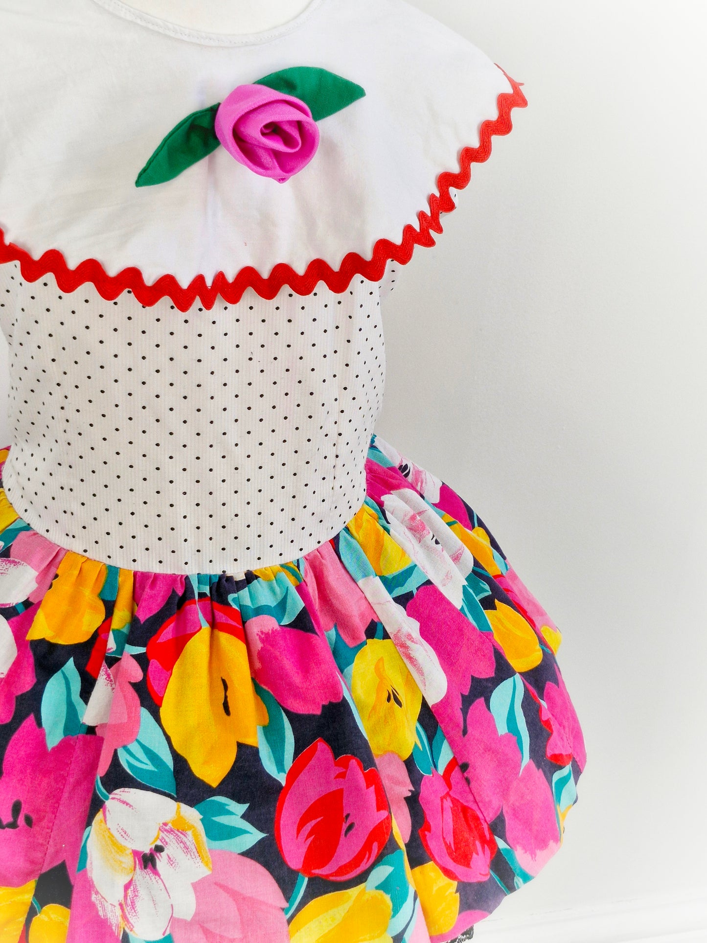 3-4 years. 80s dress, white with polka dot, floral skirt, large bib with rose. Black lace hem.