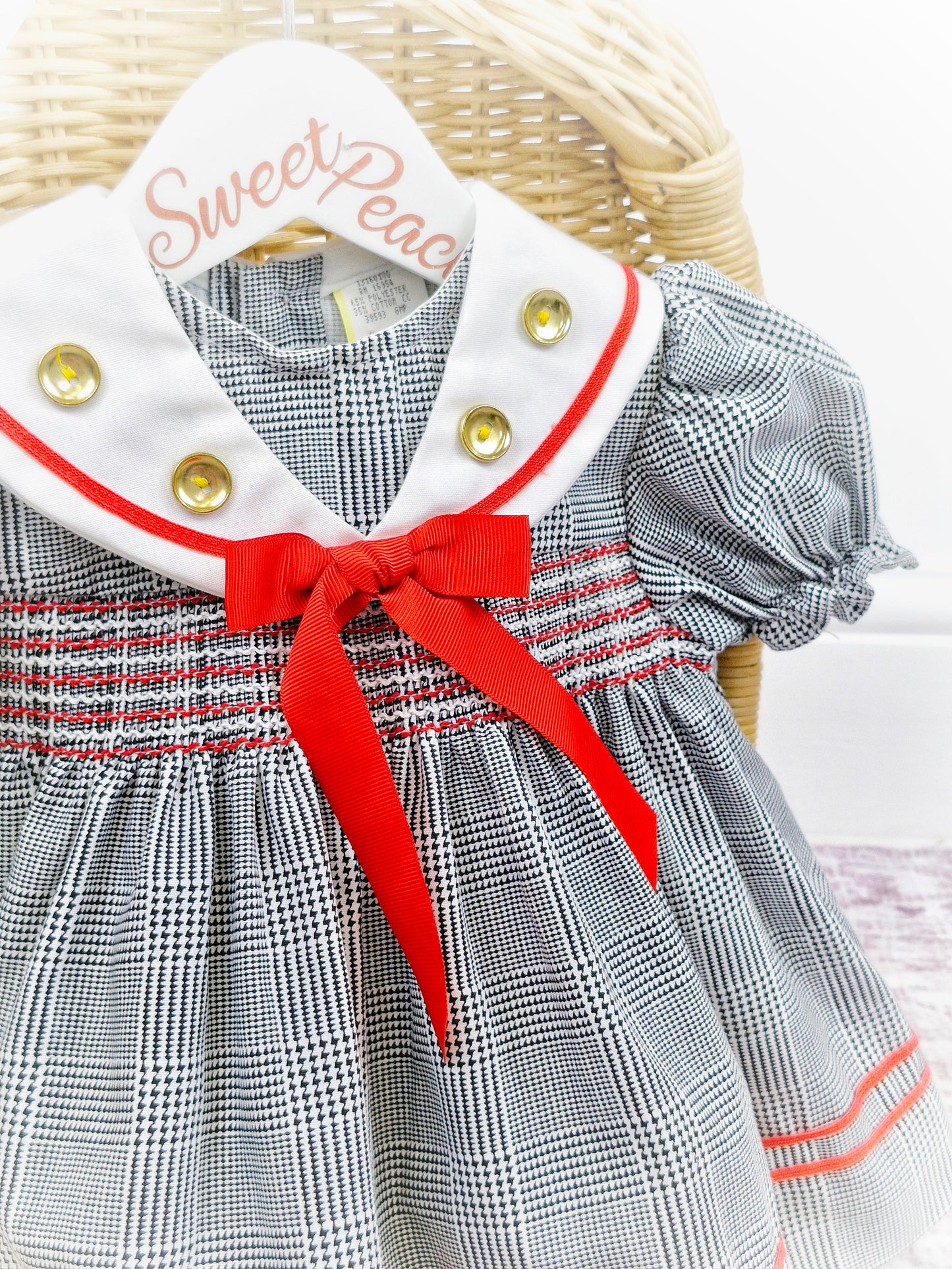 12-18 months. Black and white checked dress with red details and gold buttons