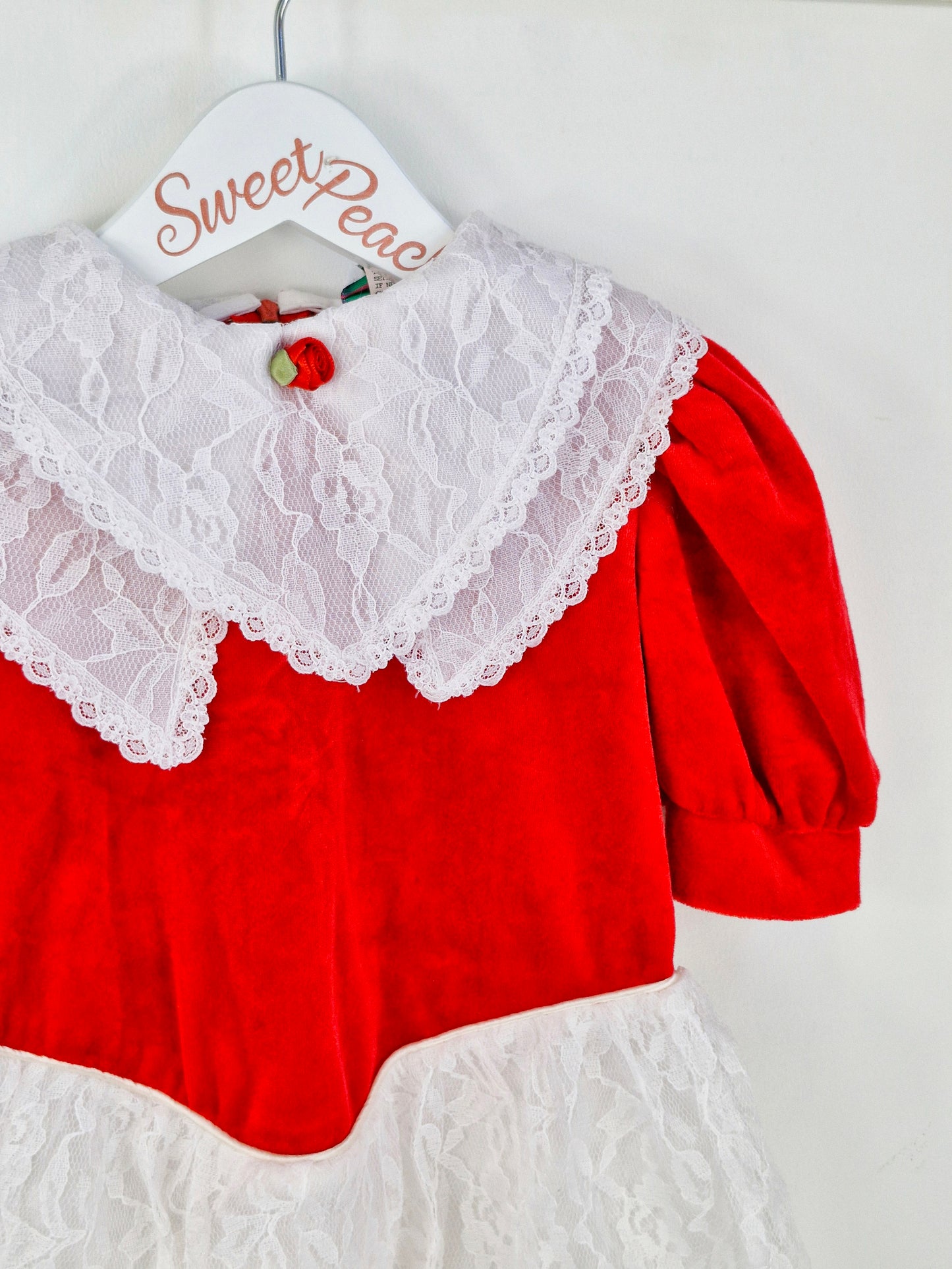 3 years. Red velour dress with white lace, double bib and skirt. Red rosette.