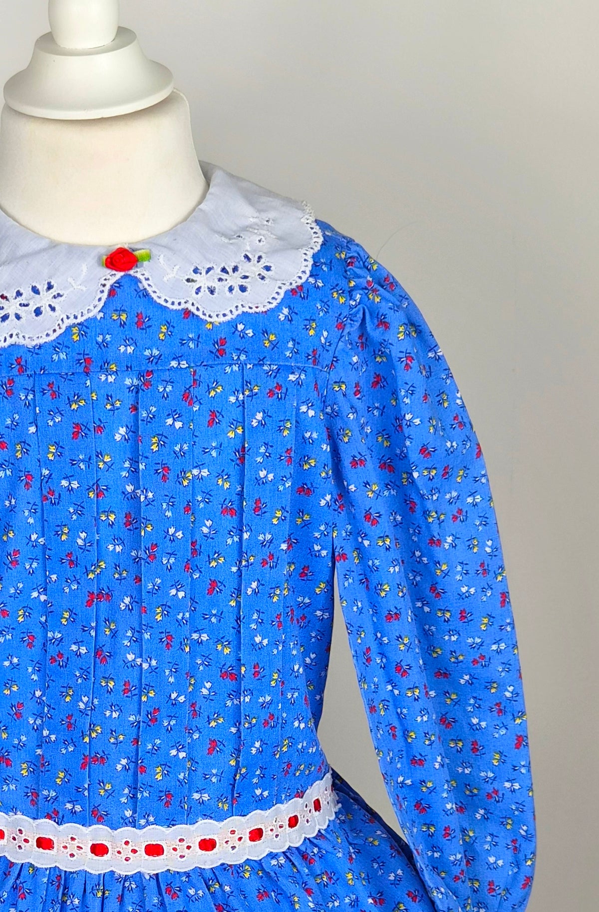 4 years. Blue vintage floral dress from Evy with white eyelet collar, red rosette and ribbon