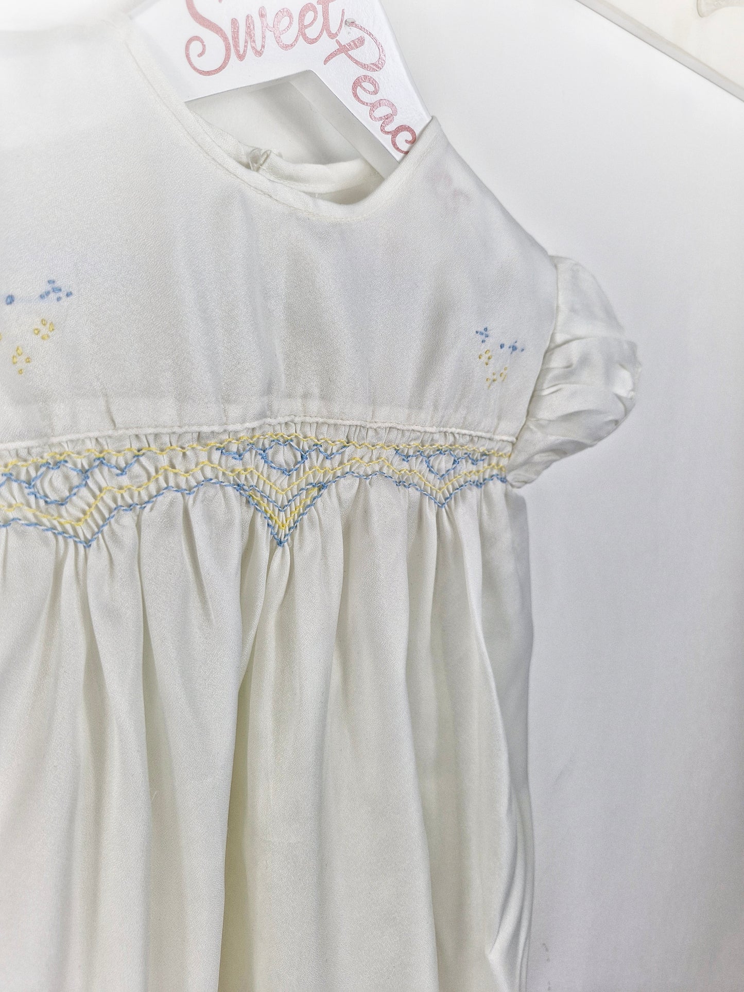 Best fit 2-3 years. Ivory satin unisex romper with lemon and blue smock embroidery