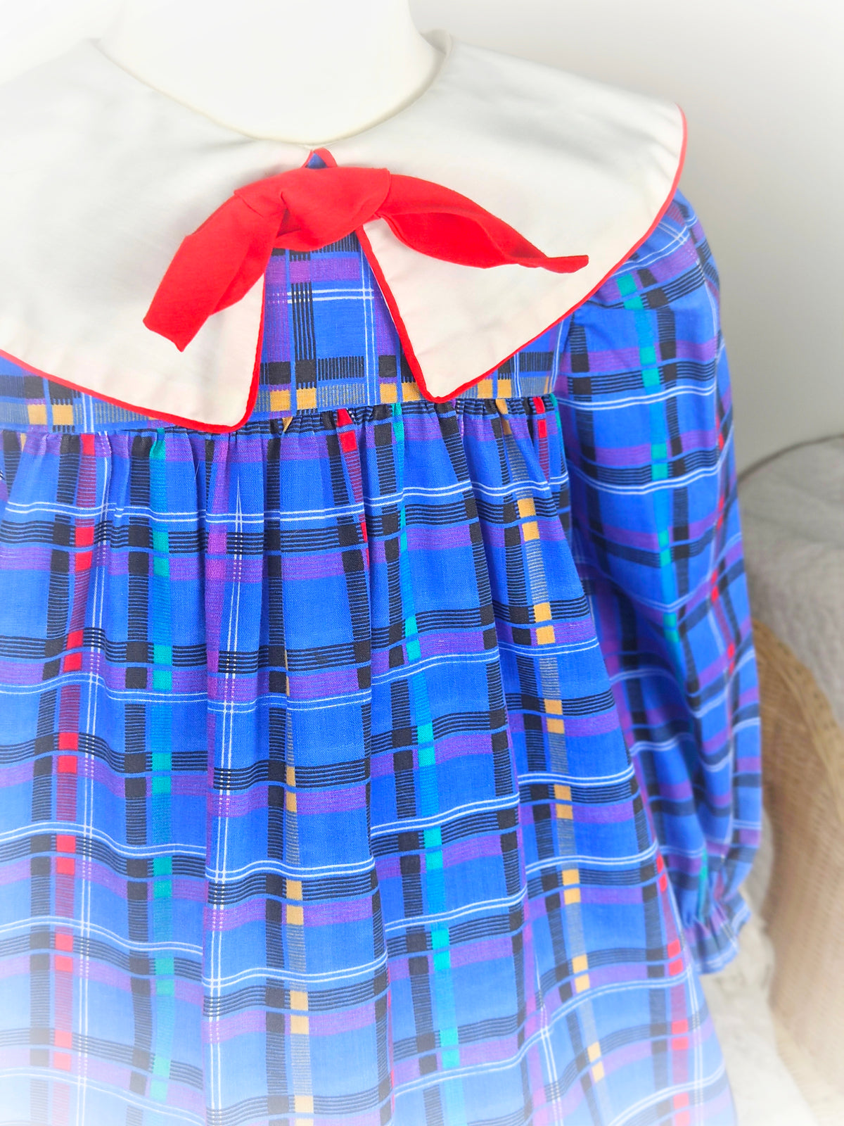 5 years. Blue checkered vintage dress with bright patterns, white collar and red bow. Little Evie