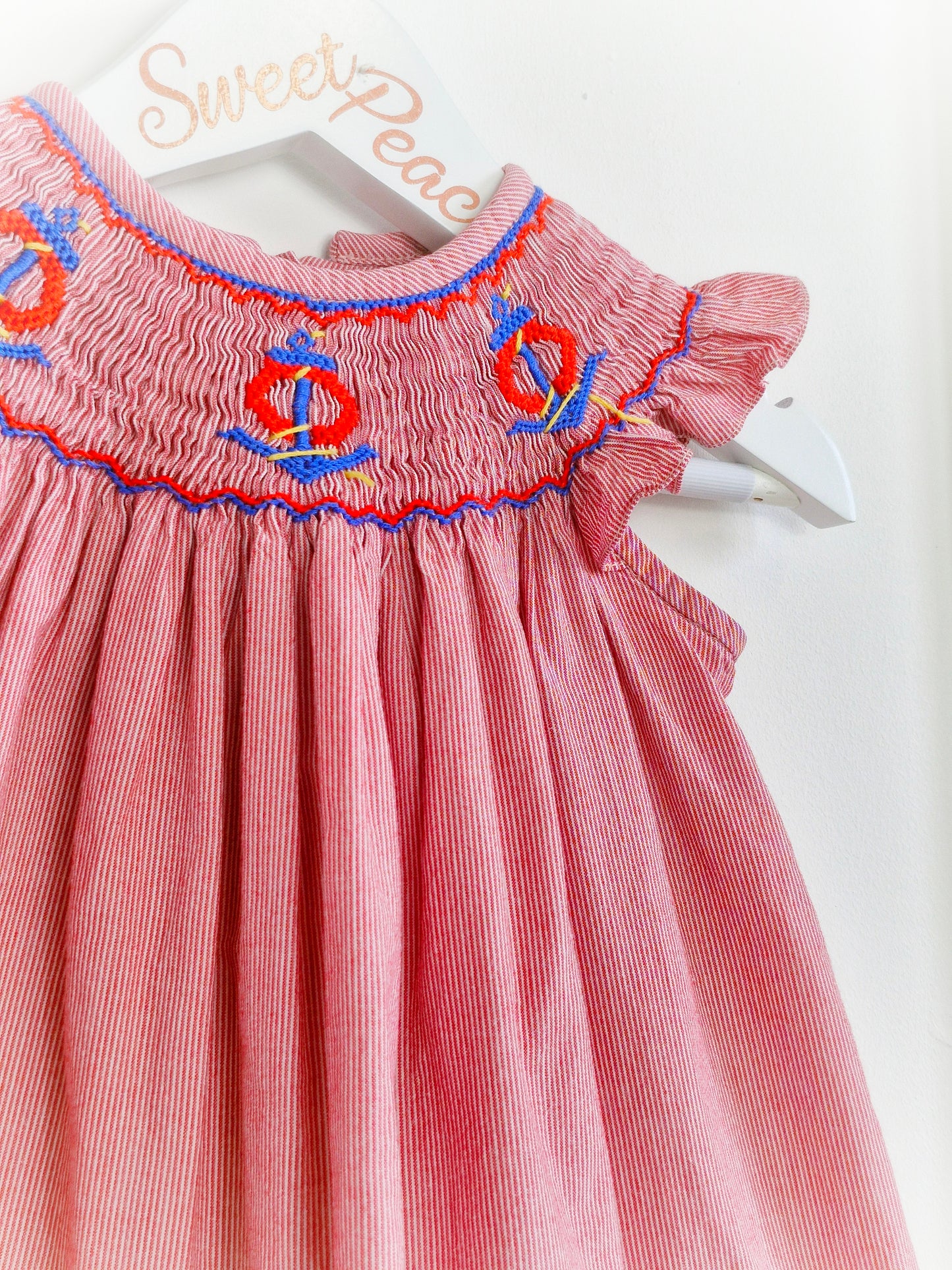 9-12 months. Vintage inspired, red and white striped dress with flutter sleeves, smocking and embroidered anchors